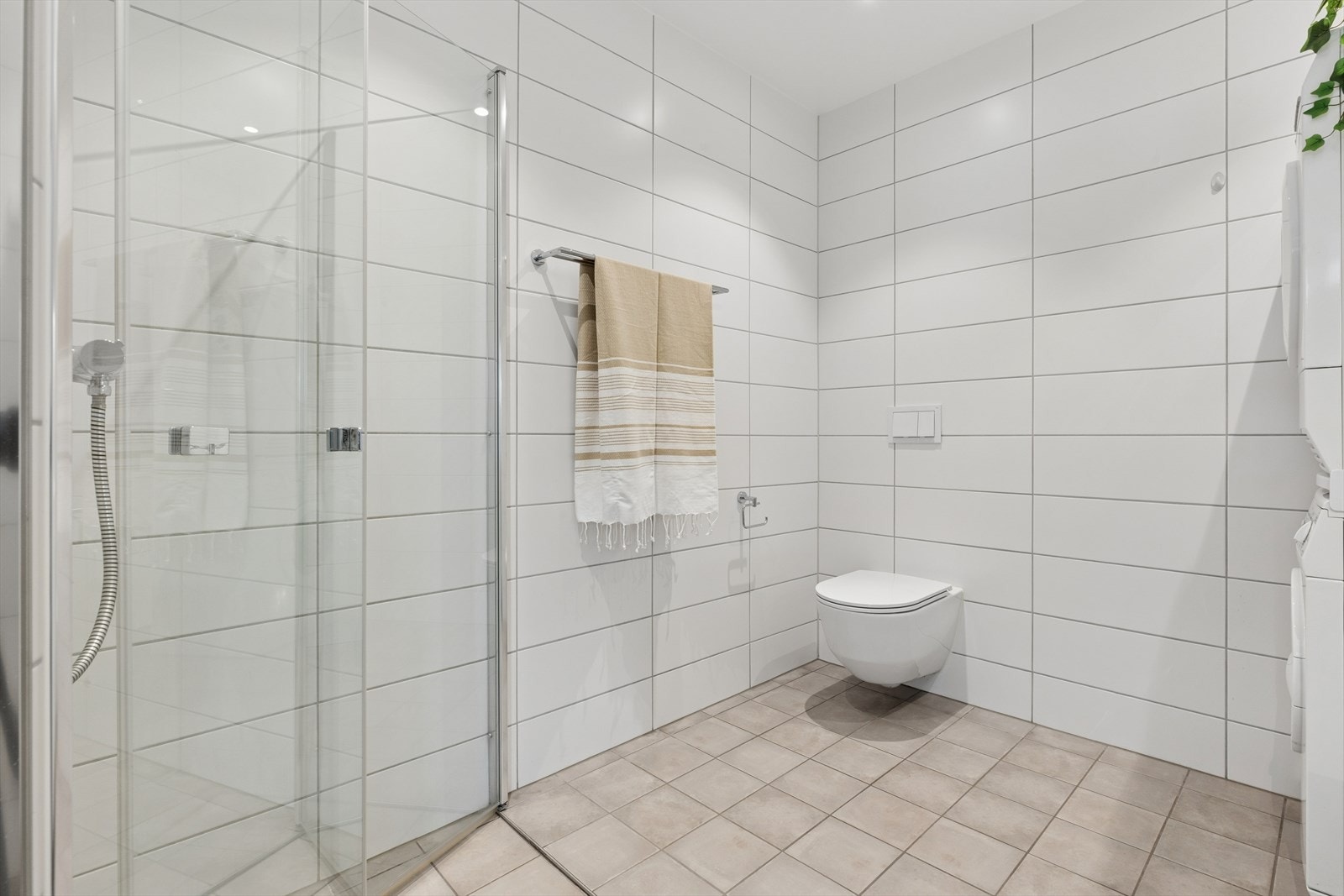 Badet har dusjhjørne med glassdører, vannbåren varme i gulvet og downlights i taket. Galleribilde