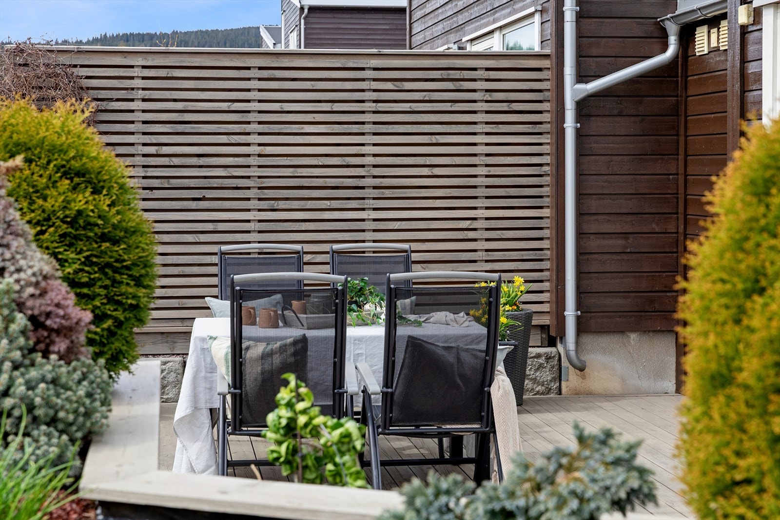Uteplassen er pent rammet inn med beplantning og levegg, som skaper en privat atmosfære. Galleribilde