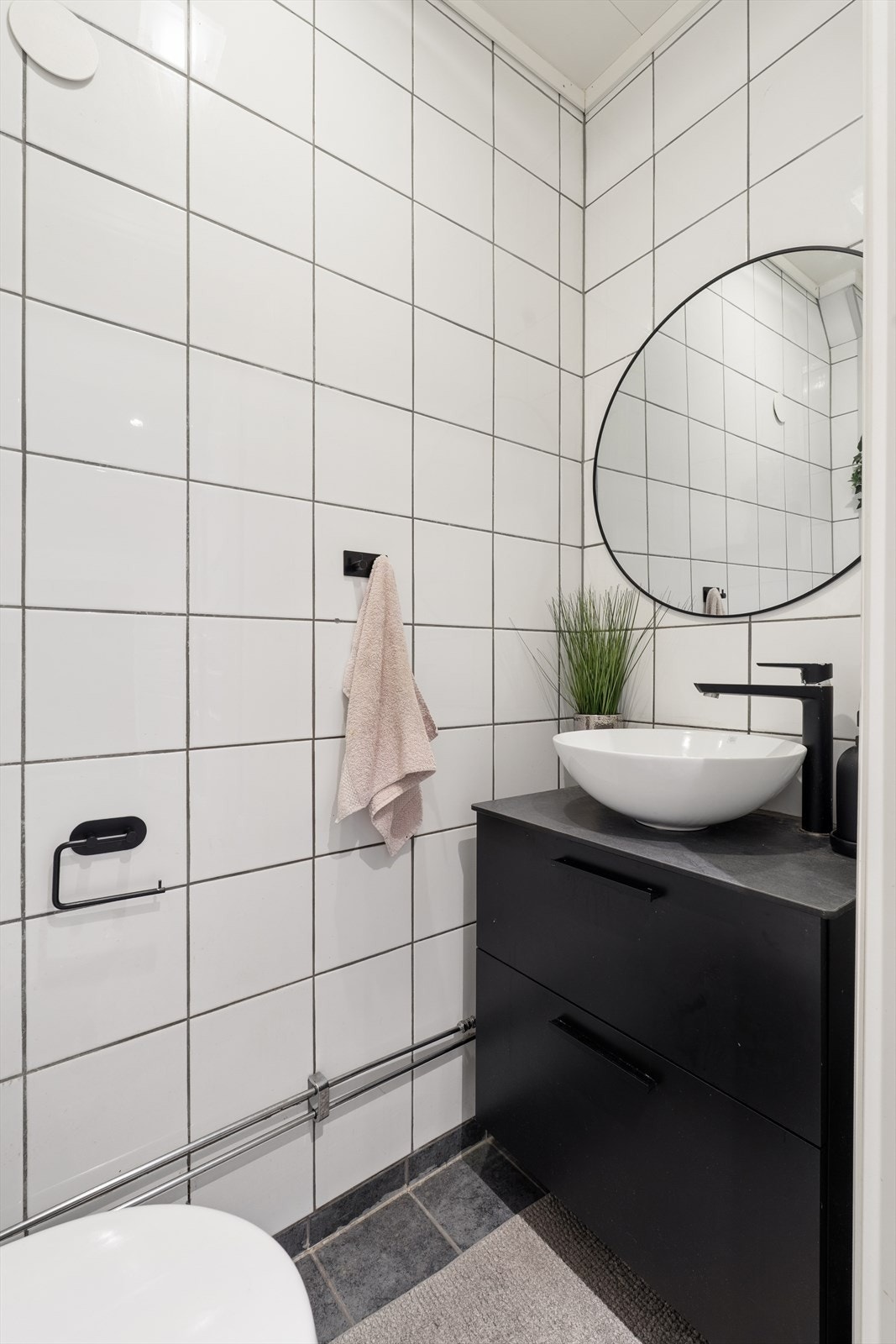 Separat WC med stilrene fliser, elegant servantinnredning og gjennomførte detaljer. Galleribilde