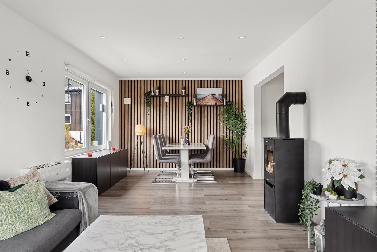 Elegant stue/spisestue med moderne uttrykk, behagelig belysning og vedovn som gir ekstra atmosfære. Galleribilde