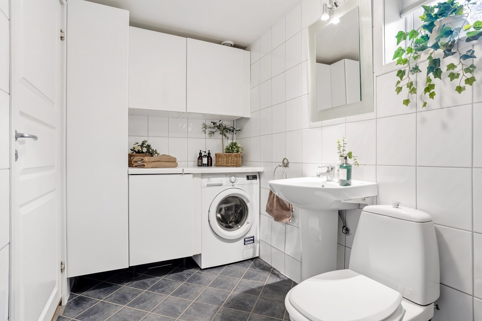Badet er utstyrt med opplegg for vaskemaskin, servant, toalett og dusj. Galleribilde