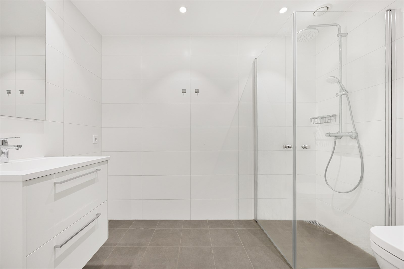 Delikat bad med flislagte overflater, gulvvarme og downlights. Galleribilde