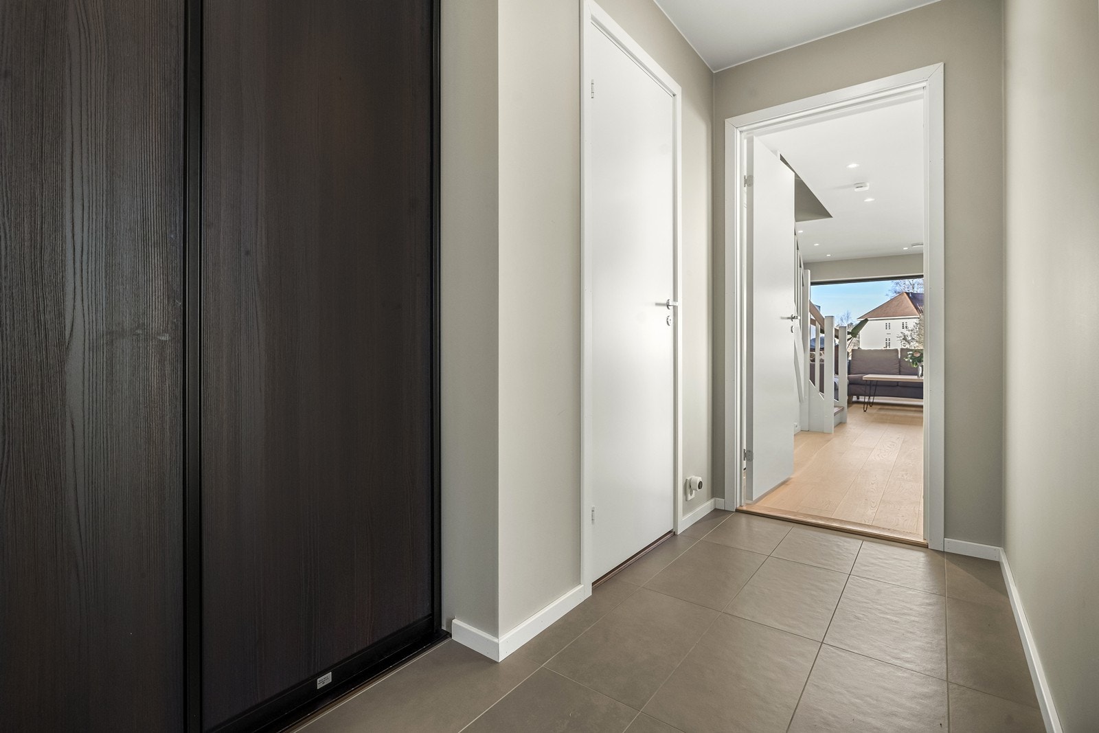 Entréen har flislagt gulv med gulvvarme og flott skyvedørsgarderobe. Fra entréen er det inngang til et toalettrom og den åpne stue- og kjøkkenløsningen. Galleribilde