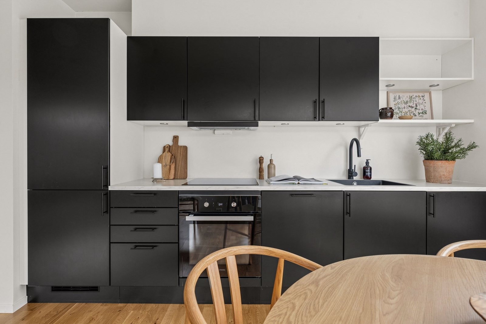 Kjøkkenet er stilrent og moderne innredet med sorte, slette fronter og lys benkeplate i laminat. Et godt utnyttet kjøkken som gir god lagringsplass i skap og skuffer. Galleribilde