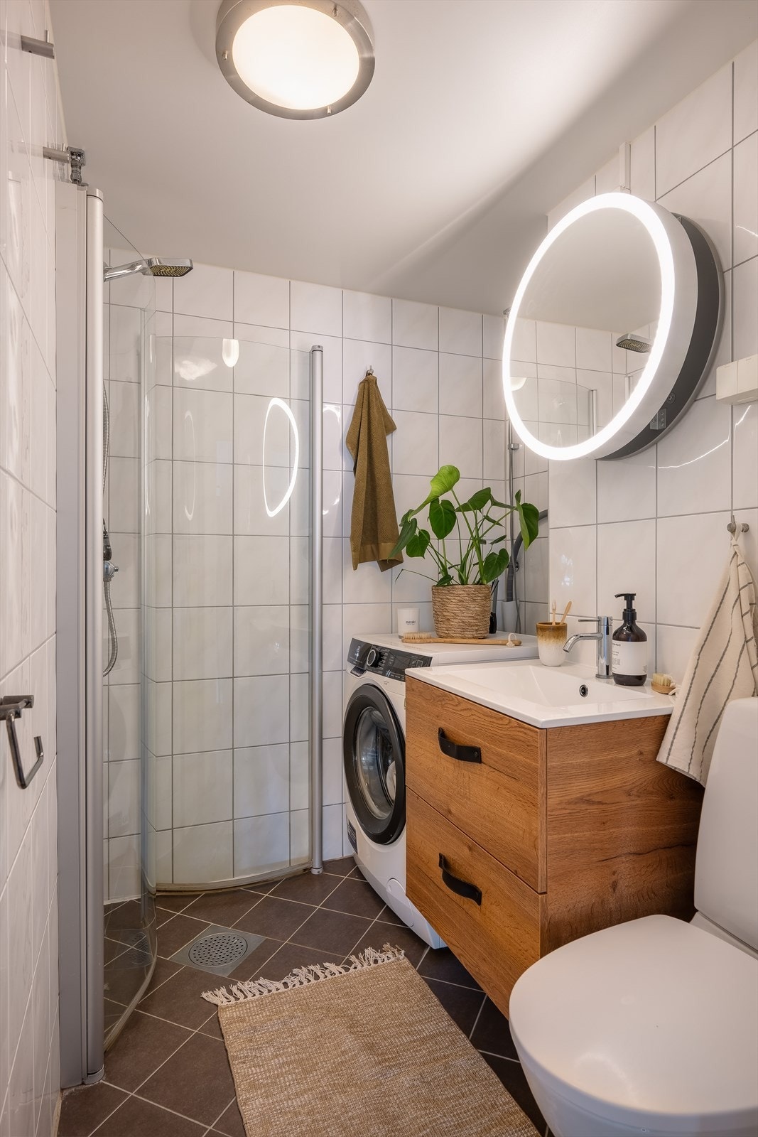 Badet er innredet med servant på servantskap, dusjhjørne, toalett og opplegg for vaskemaskin. Galleribilde