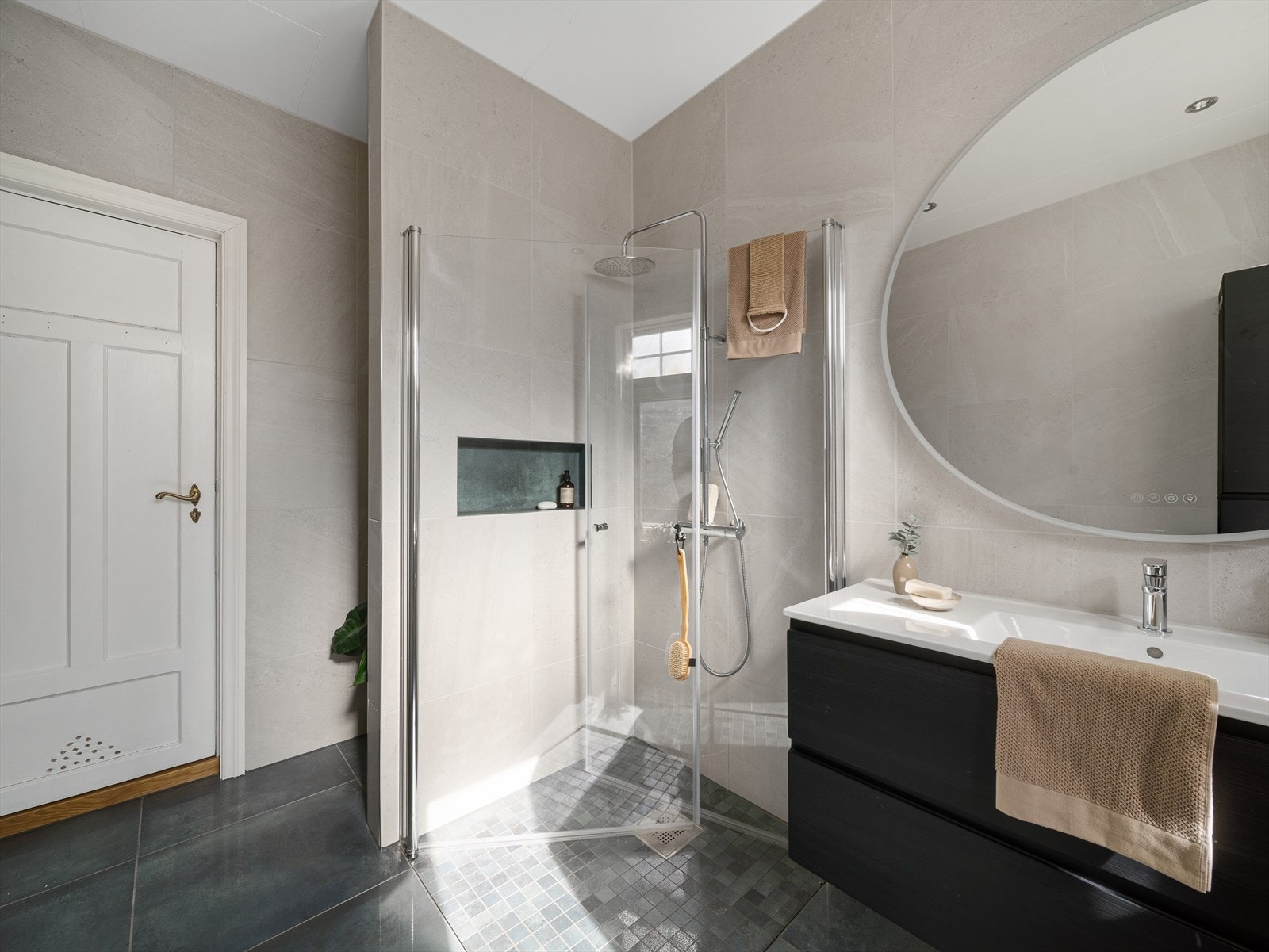 Badet er innredet med baderomsinnredning med servant, dusj og nisje for vaskemaskin. Galleribilde