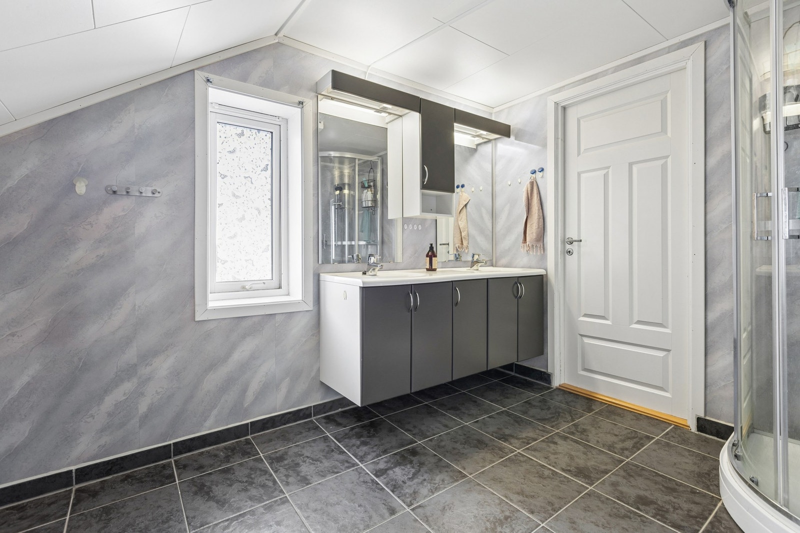 Bad med skråtak gir en luftig følelse. Moderne innredning med 2 vasker. Galleribilde