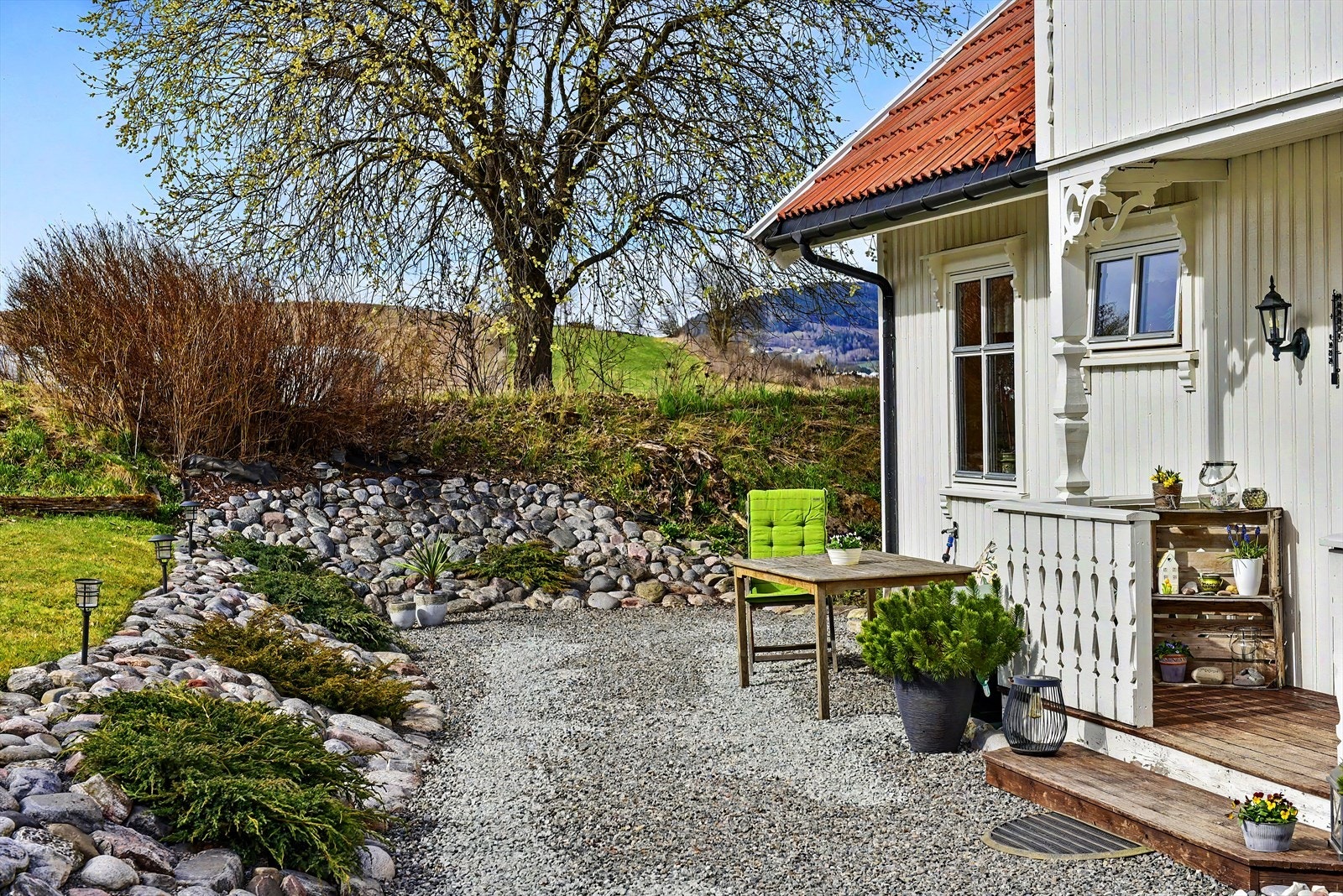 Eiendommen har en pent opparbeidet hage med gruslagte stier og beplantning. Galleribilde