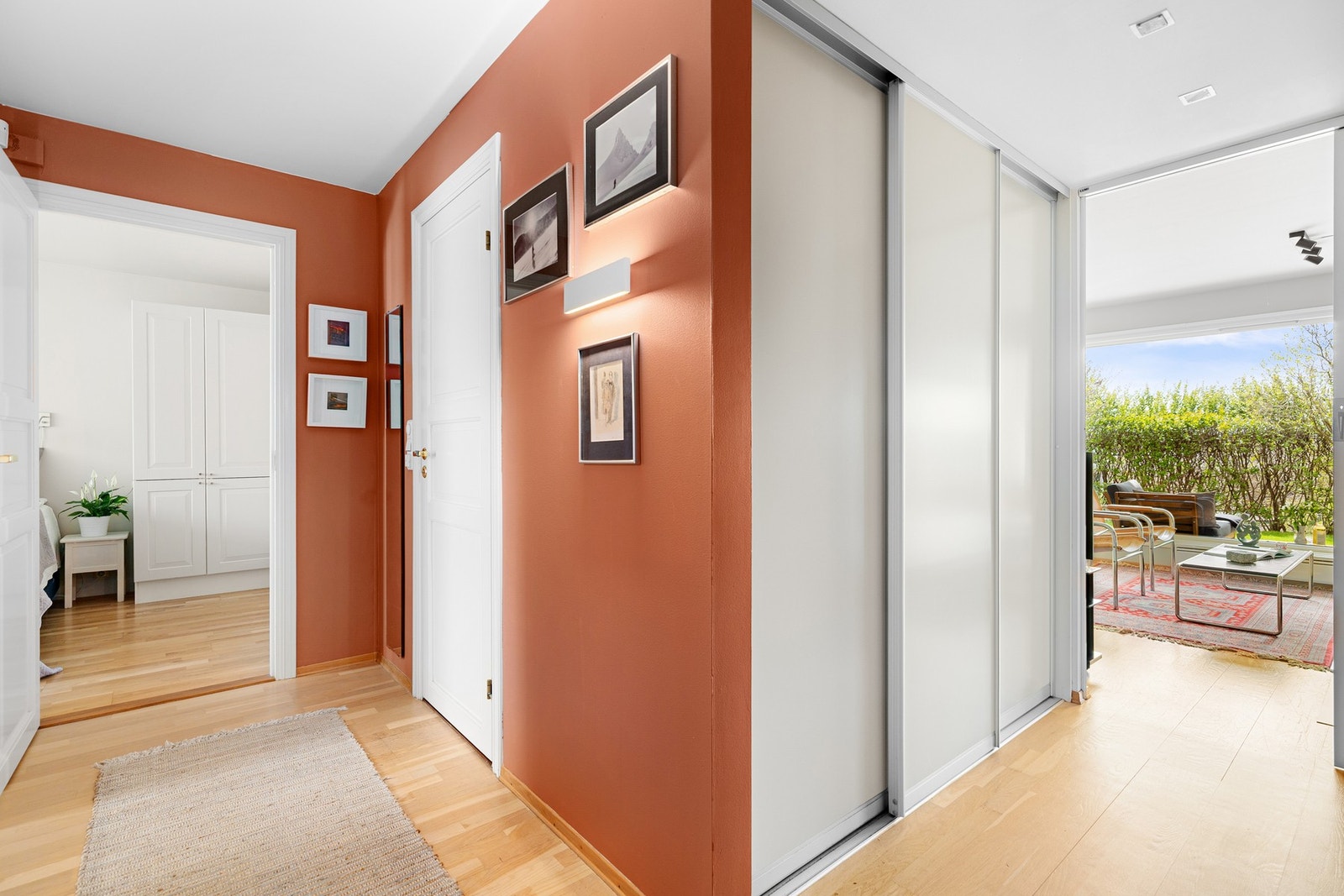 Mellomgangen mellom entré og stue er innredet med skyvedørsgarderobe på hver side. Galleribilde
