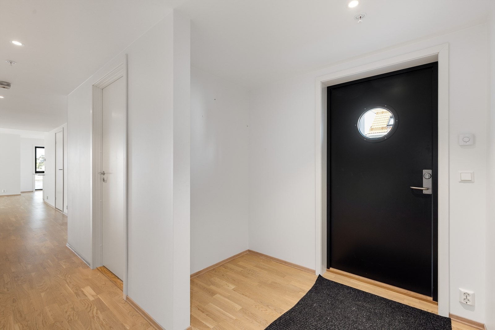 Entréen fremstår lys og innbydende, med plass til oppbevaring og en naturlig flyt videre inn i boligen. Galleribilde