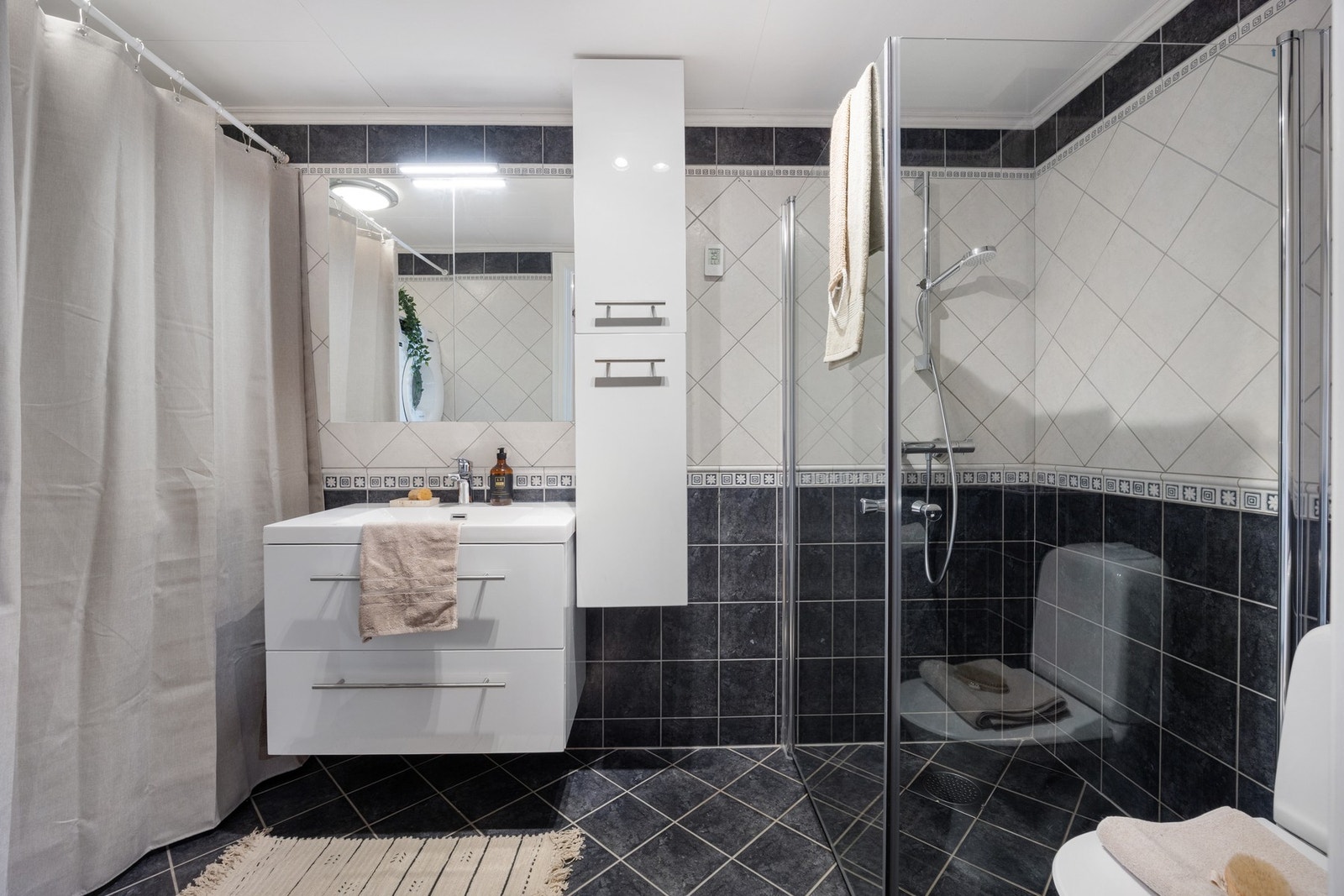 Badet er innredet med fliser på gulv og vegger, med avtrekk via balansert ventilasjonsanlegg Galleribilde