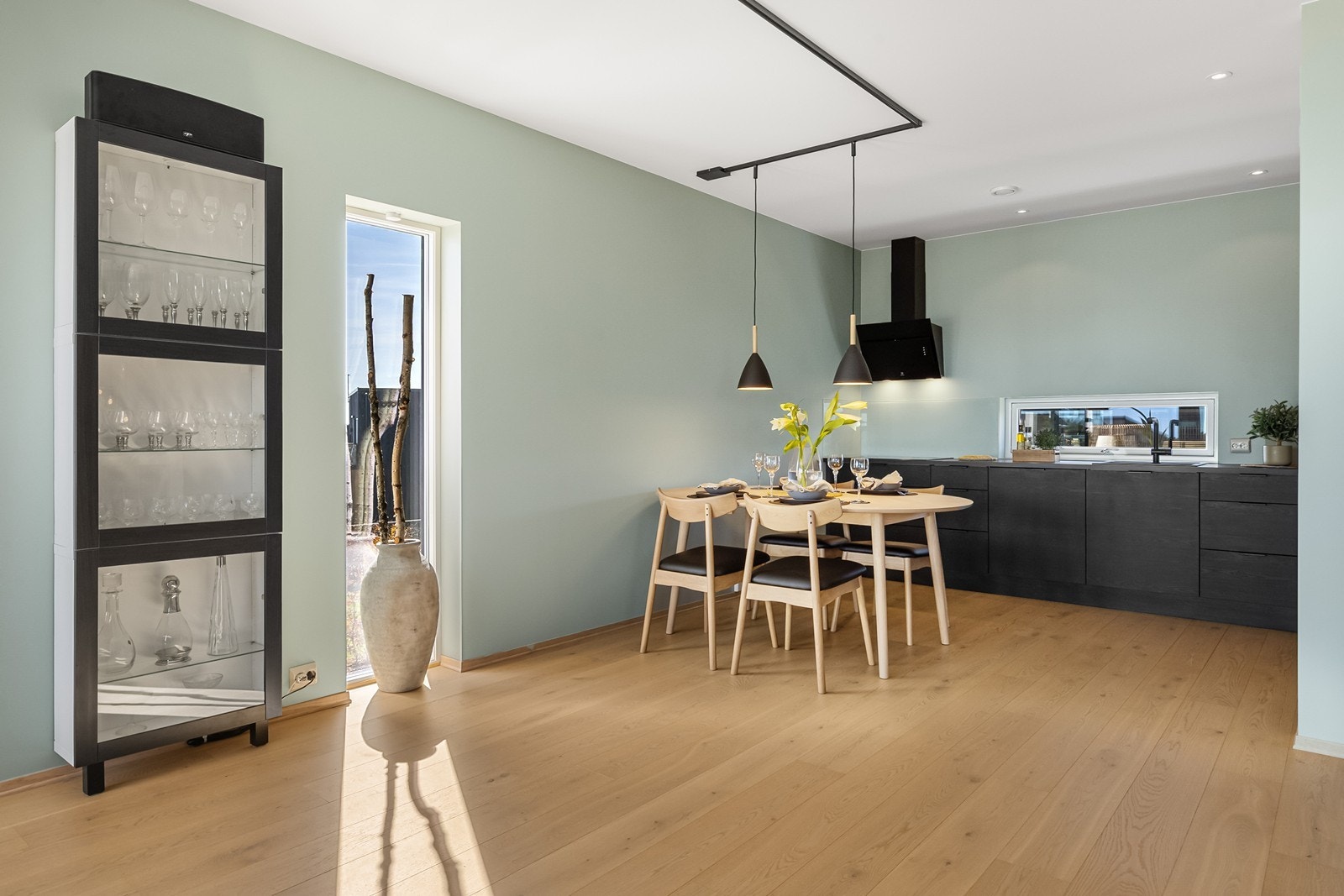 Kjøkkenet har åpen løsning mot stuen, og en moderne innredning med mørke fronter og ventilator. Galleribilde