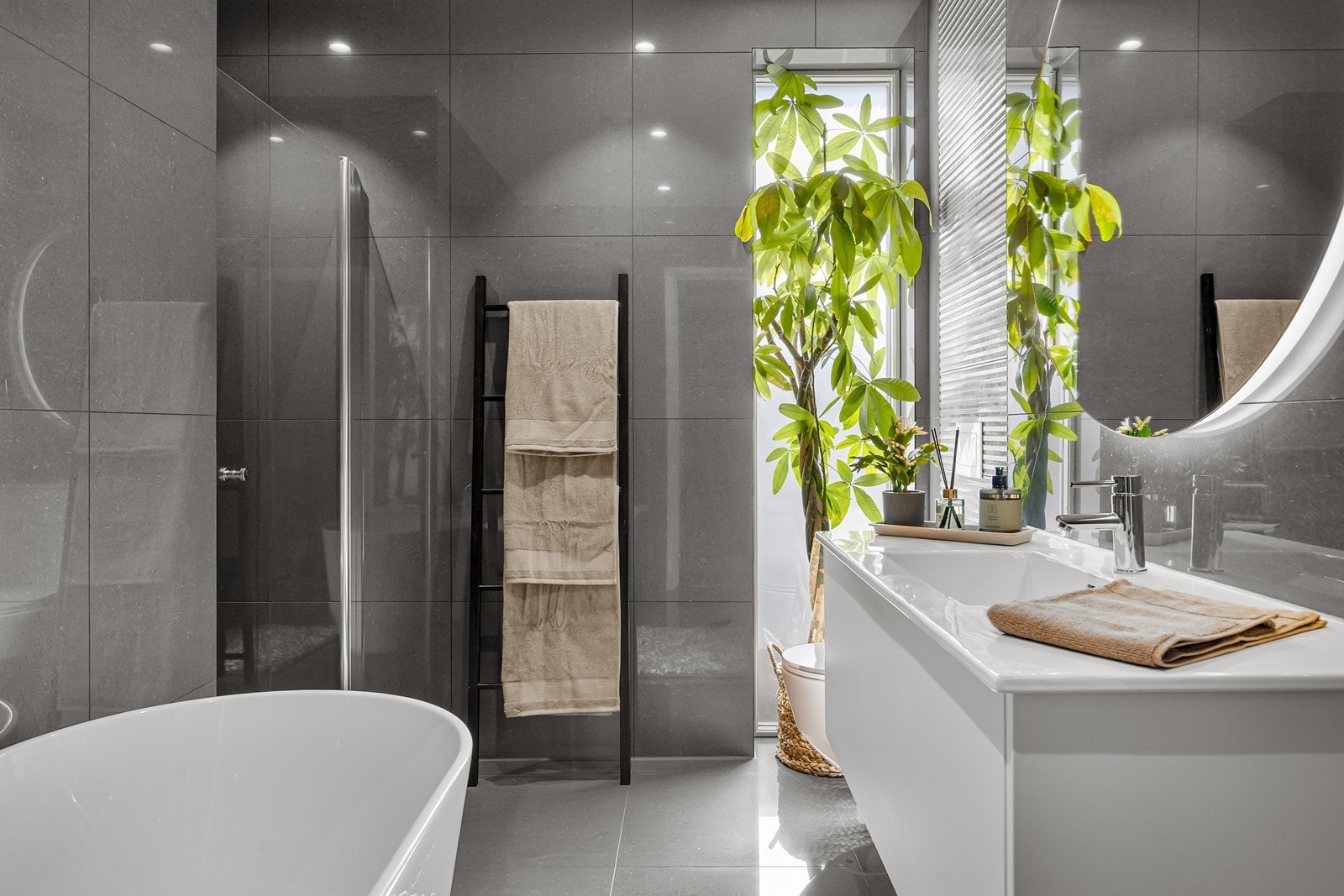Flislagte vegger og gulv gir badet et helhetlig og luksuriøst uttrykk. Galleribilde