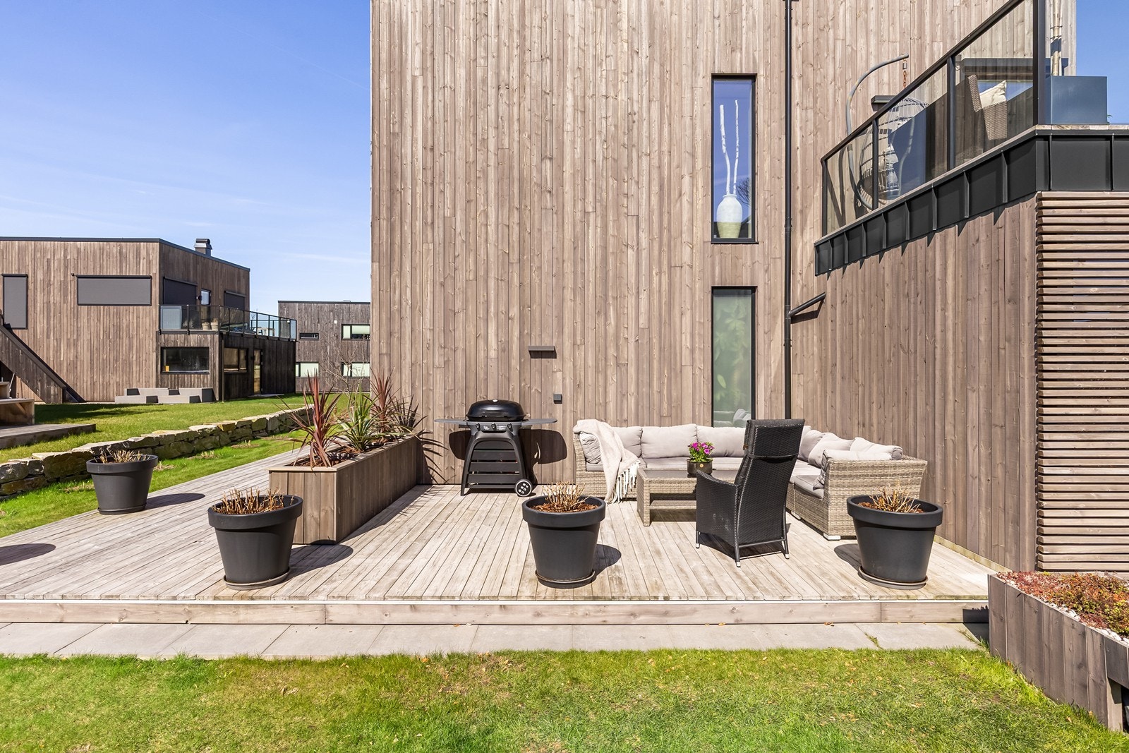 Treterrassen gir rom for avslapning og er omkranset av en grønn fin hage. Galleribilde