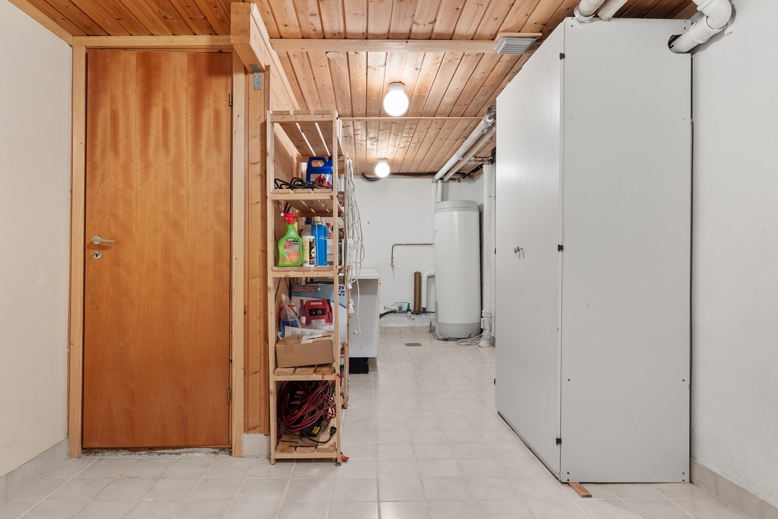 Stor bod/materialrom med flislagt gulv, skapinnredning og varmtvannsbereder Galleribilde