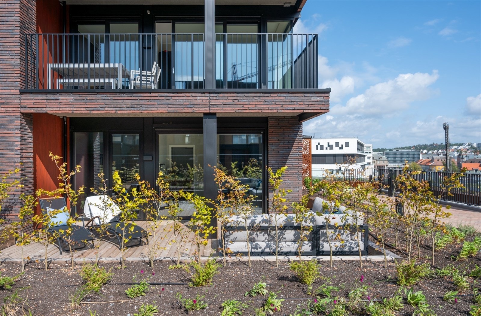 Terrassen er anlagt med impregnerte terrassebord og er rammet inn av beplantning. Galleribilde