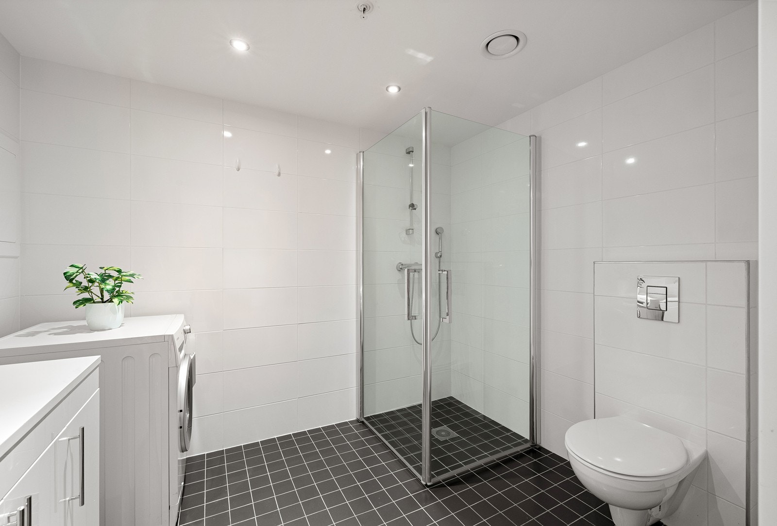 Badet er utstyrt med servantmøbel, speil med lys og stikkontakt, samt dusjsone med innfellbare glassvegger. Galleribilde