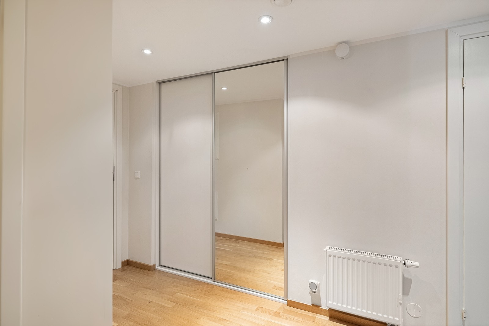 I tilknytning til entréen er det en romslig skyvedørsgarderobe for praktisk oppbevaring av yttertøy og sko. Galleribilde
