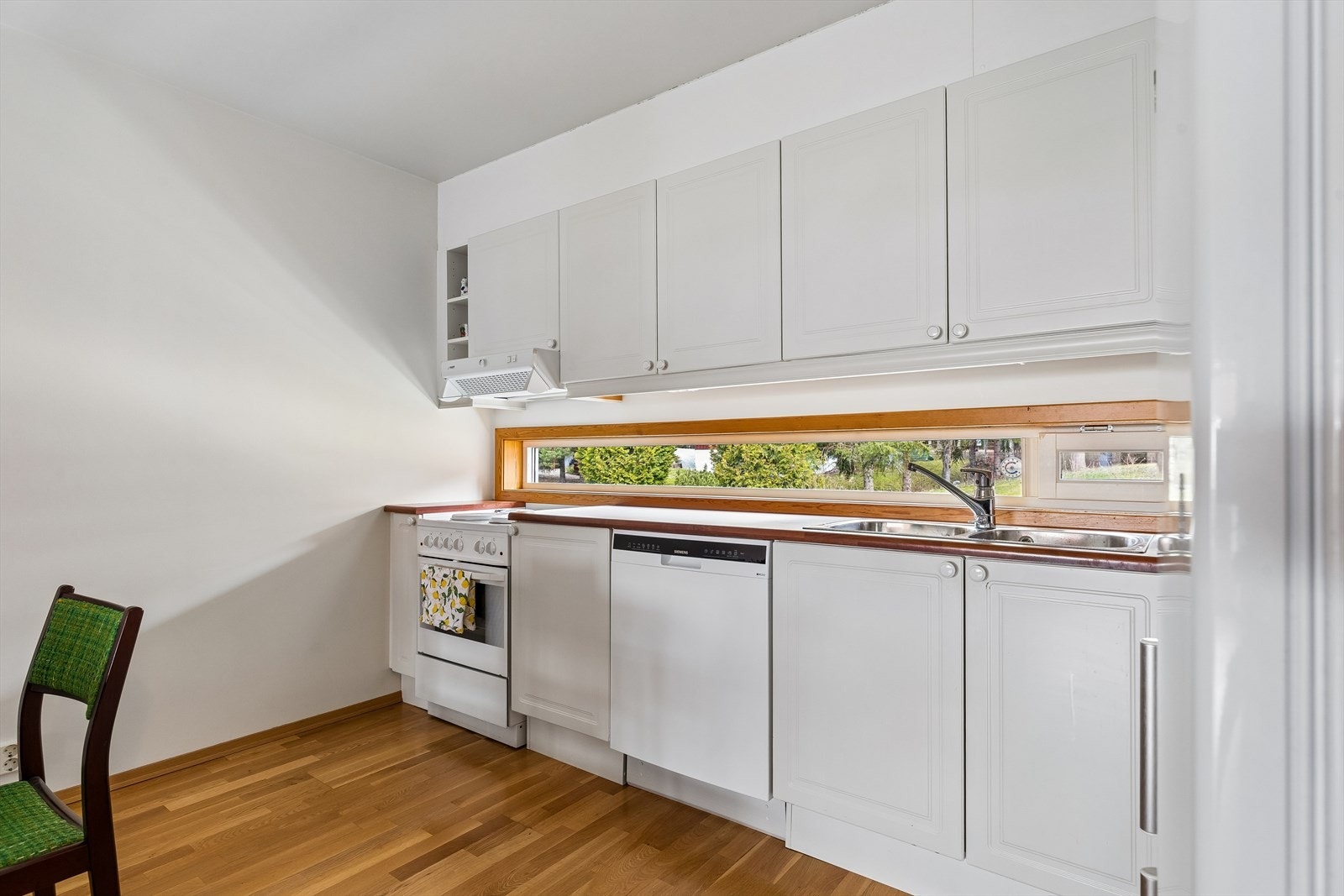 Kjøkkeninnredning med profilerte fronter, laminatbenkeplate og nedfelt dobbel oppvaskkum. Galleribilde