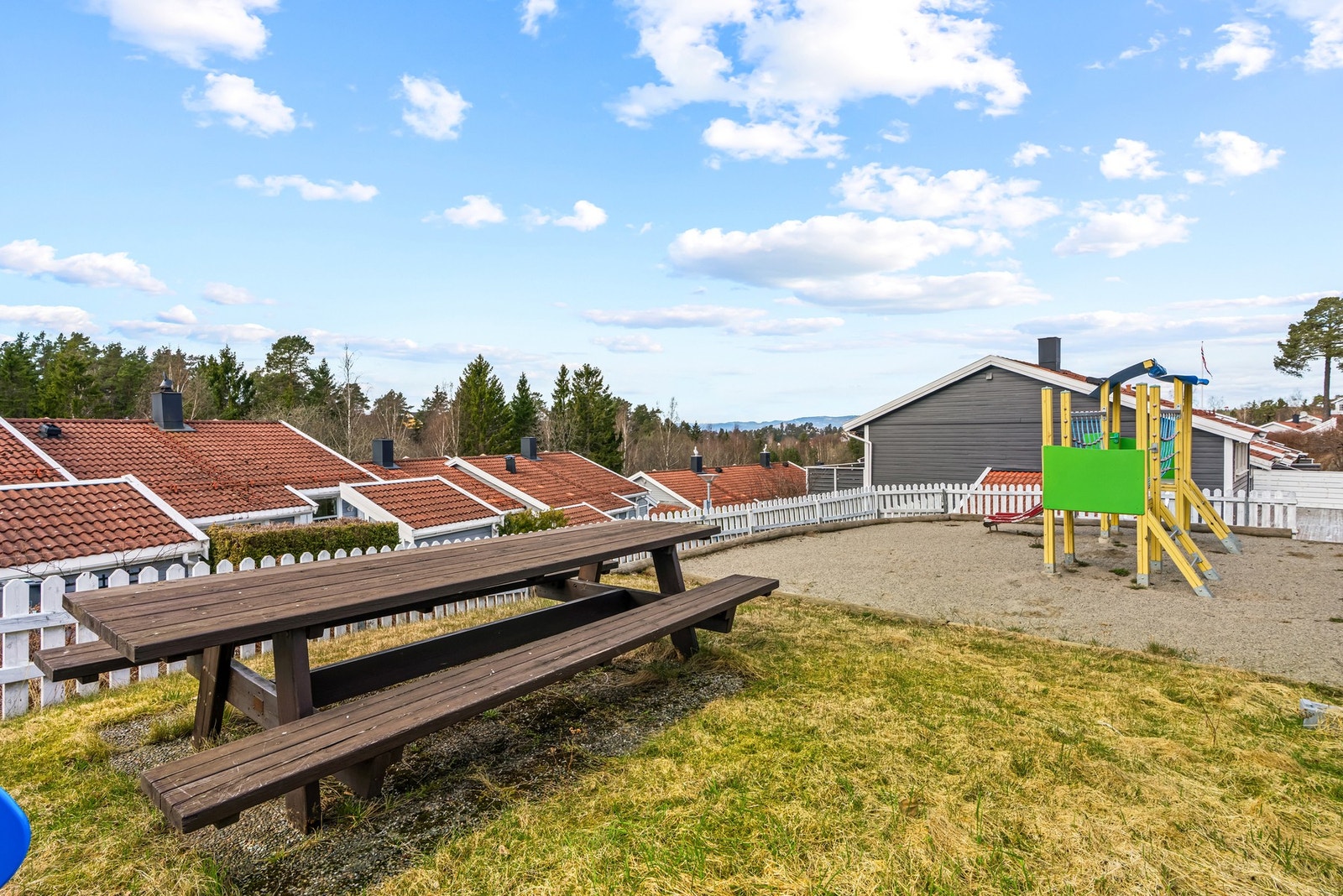 Lekeplass rett på oversiden av boligen med sitteplasser og lekestativ - perfekt om man har småbarn i hus Galleribilde