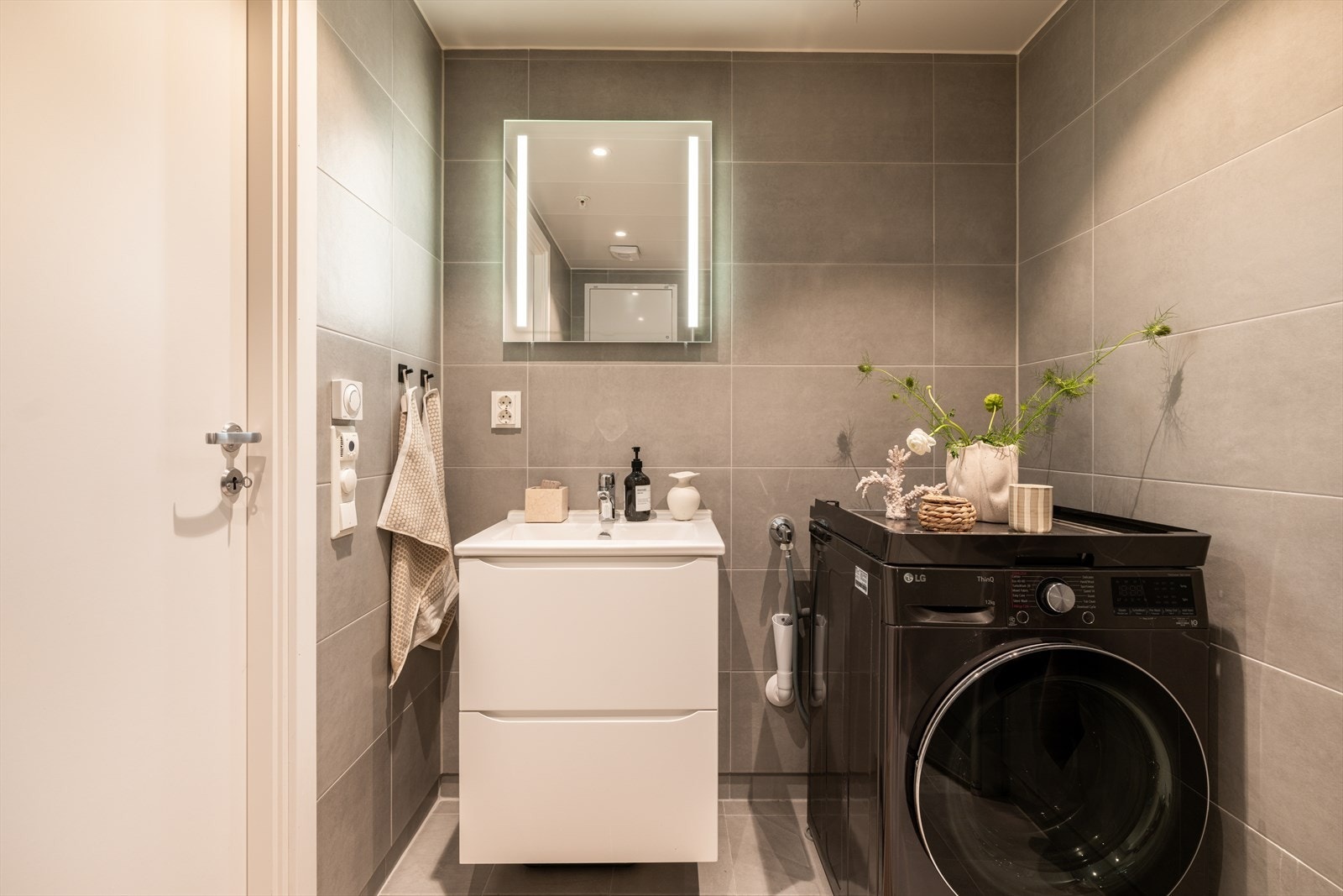 Badet har lys, moderne innredning og opplegg for vaskemaskin. Galleribilde