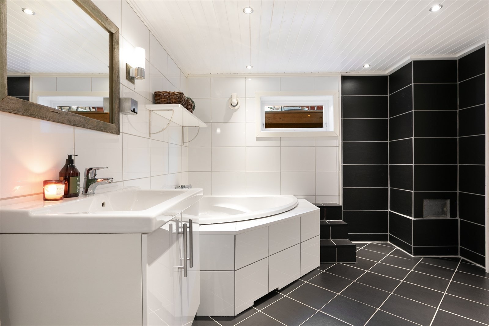 Badet i kjelleretasje inkluderer flislagte gulv med gulvvarme og innbygget badekar. Galleribilde