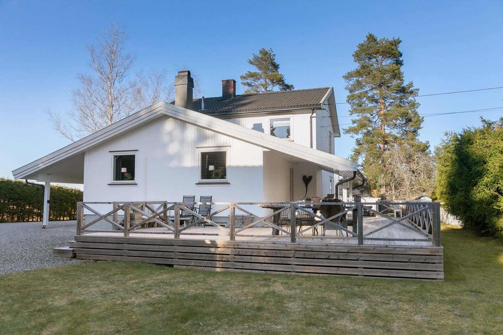 Gårdsplassen er opparbeidet med plen, belegningsstein og gruset innkjøring. Galleribilde