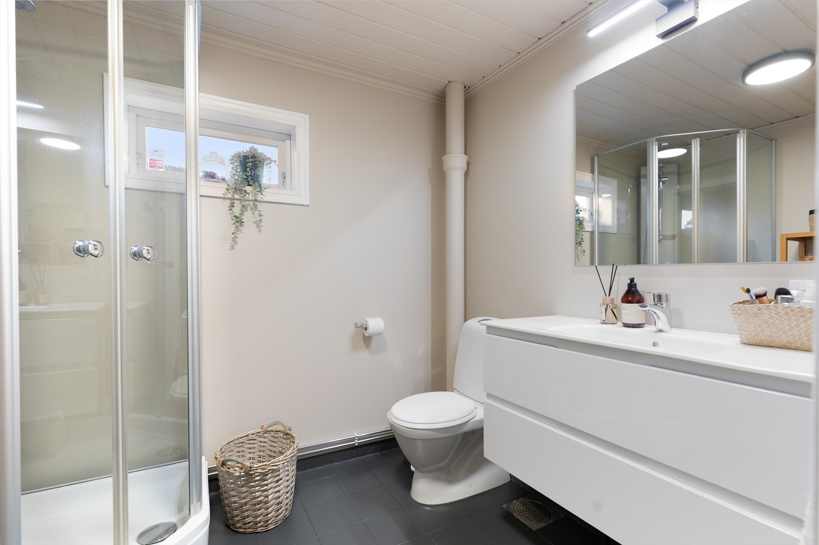 Badet i andre etasje har dusjkabinett, servant med skuffeseksjon og naturlig ventilasjon. Galleribilde