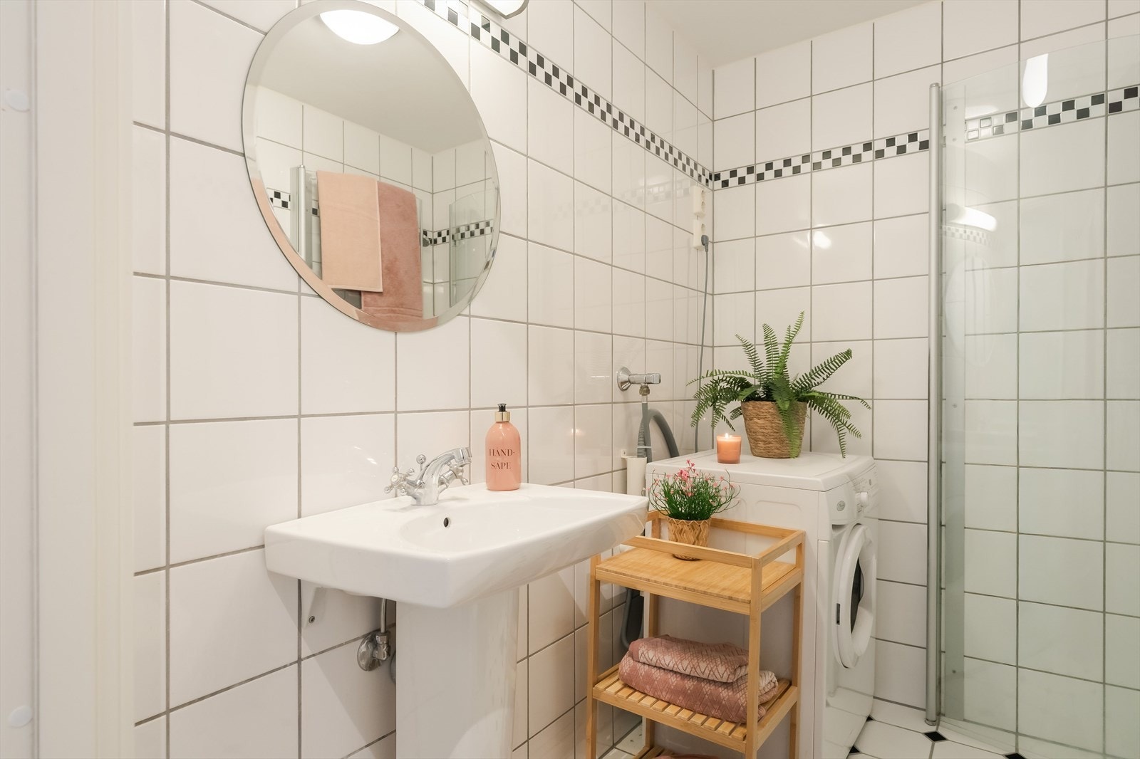 Badet er utstyrt med et toalett, opplegg for vaskemaskin og et dusjhjørne med innfellbare glassdører. Galleribilde