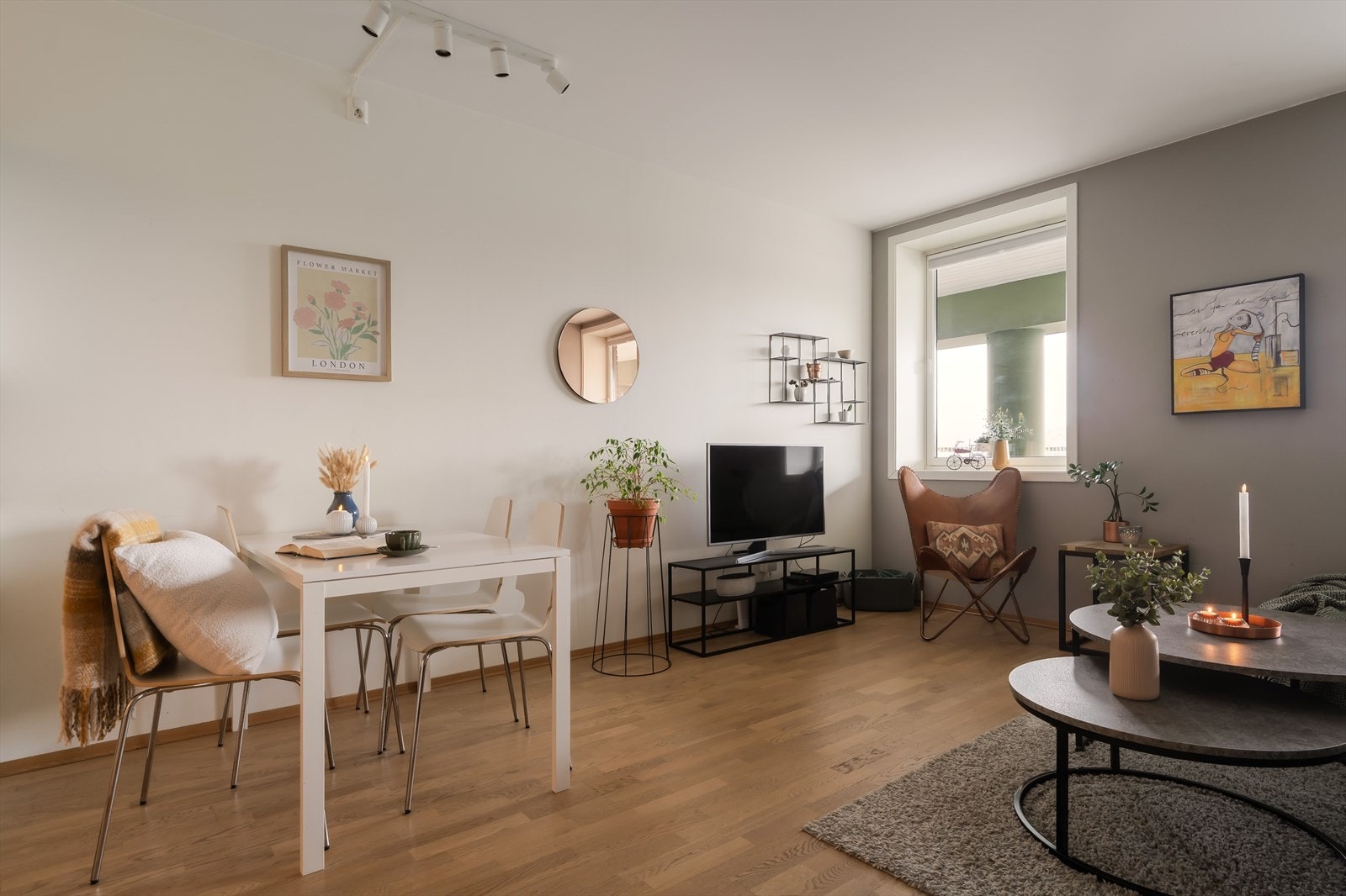 Veggene er malt opp i hvitt og grått, og allrommet har gyllen, trestavs parkett på gulvet. Galleribilde