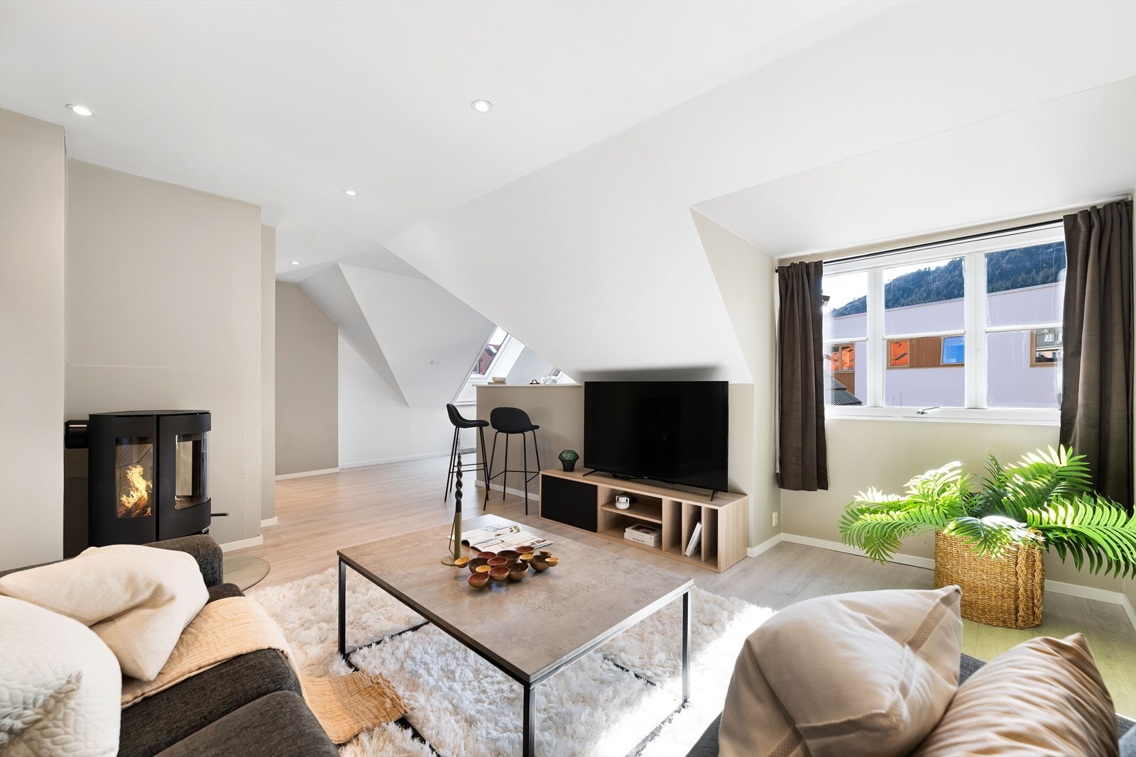 Stuen har en moderne peisovn som bidrar til både varme og en hyggelig atmosfære. Galleribilde