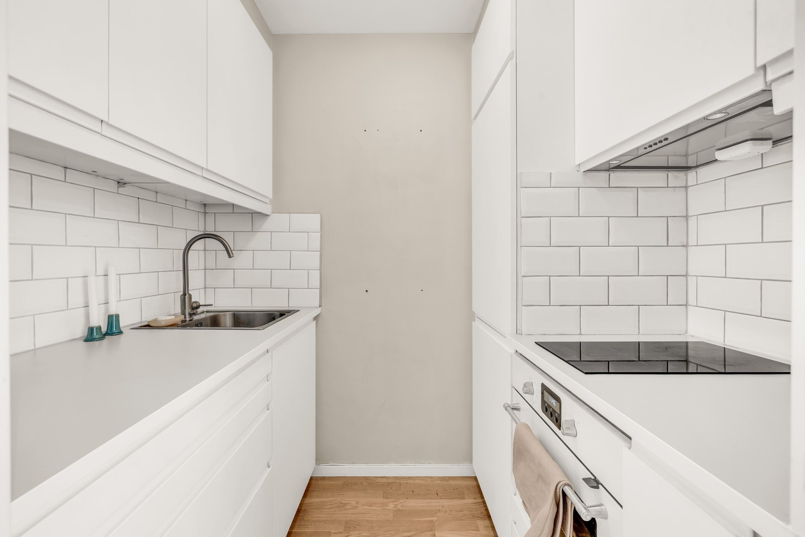 Lyst og separat kjøkken med innredning fra IKEA med slette fronter og benkeplate i laminat. Galleribilde