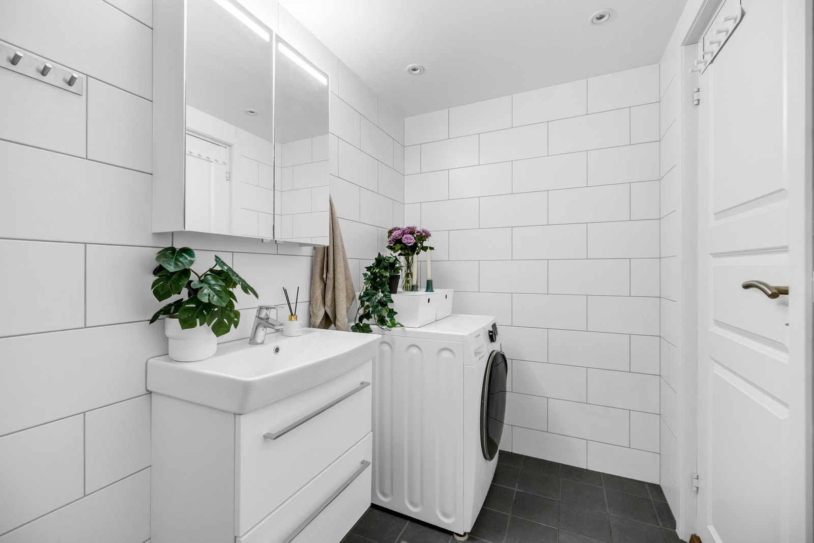 Badet er fra 2017 og er innredet med vegghengt servantinnredning i slette fronter med ovenpåliggende vask. Det er opplegg for vaskemaskin. Galleribilde