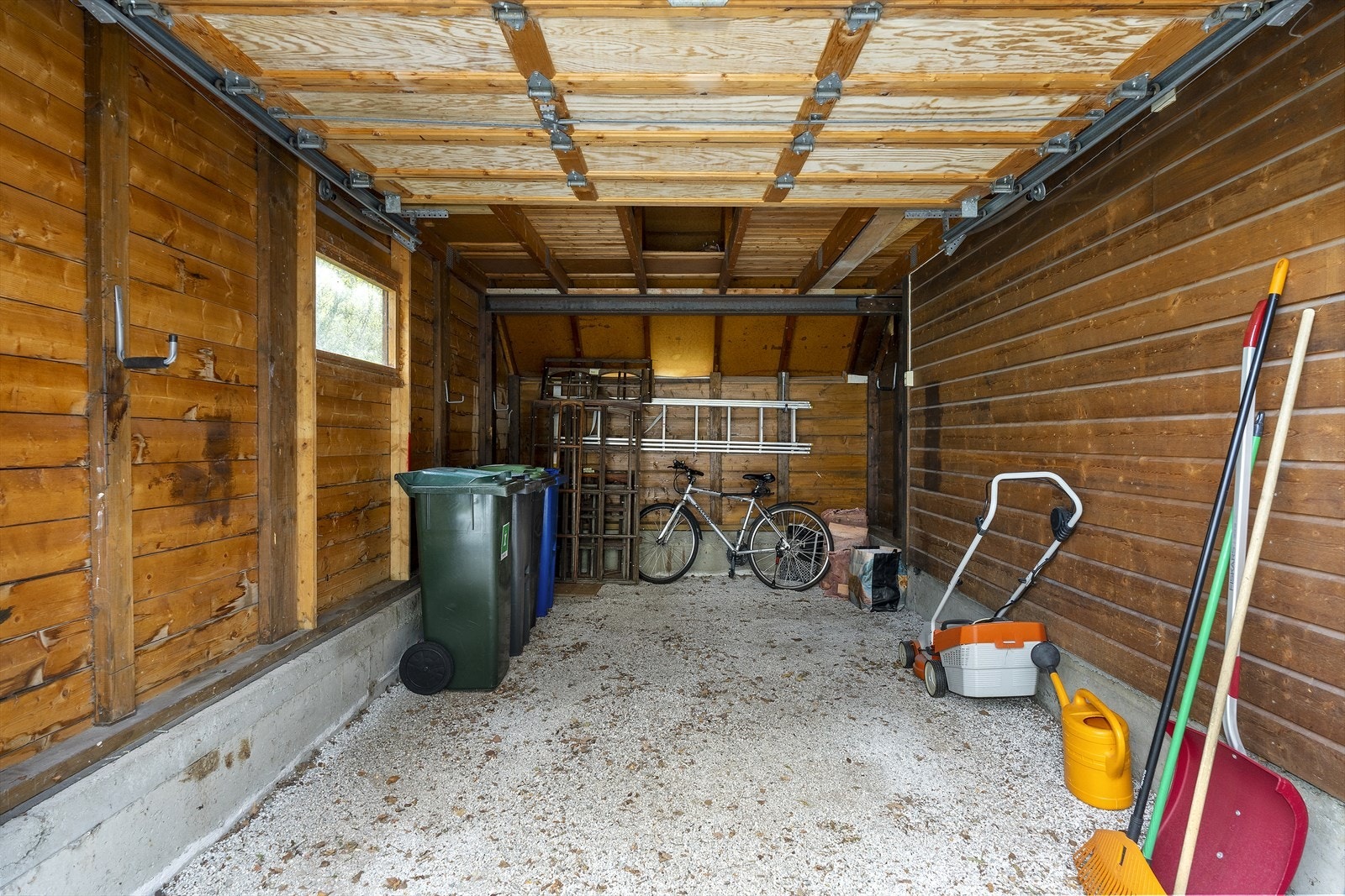 Garasjen er utstyrt med en leddport i malt tre og tilbyr praktisk oppbevaringsplass. Galleribilde