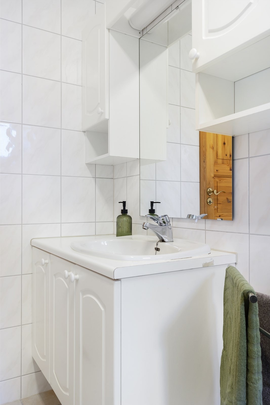 Innredningen på badet inkluderer profilerte skapfronter og en laminert benkeplate med nedfelt servant. Galleribilde