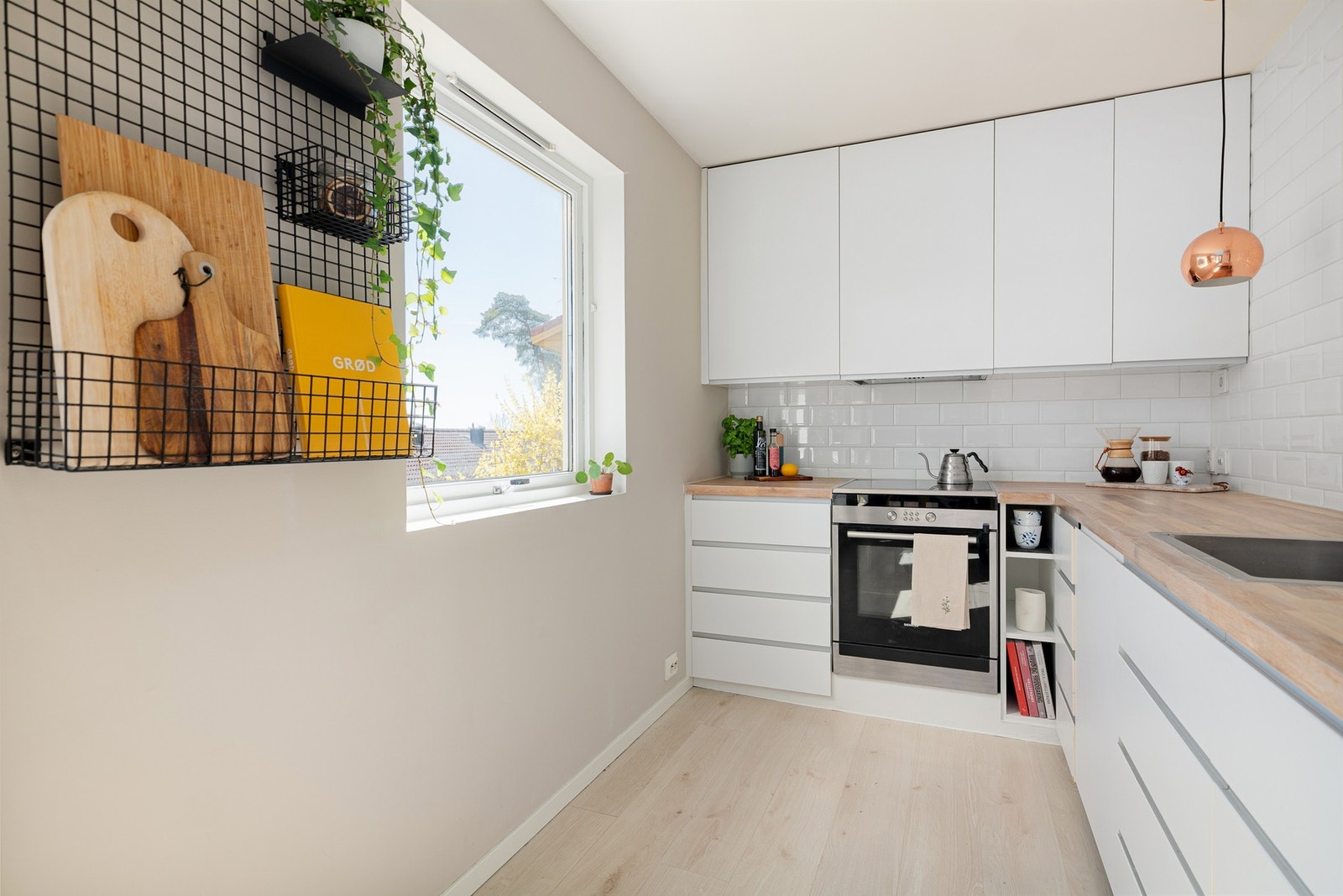 Innredningen har glatte fronter i hvit utførelse som gir et rent og tidløst uttrykk, kombinert med benkeplate i heltre som tilfører varme. Galleribilde