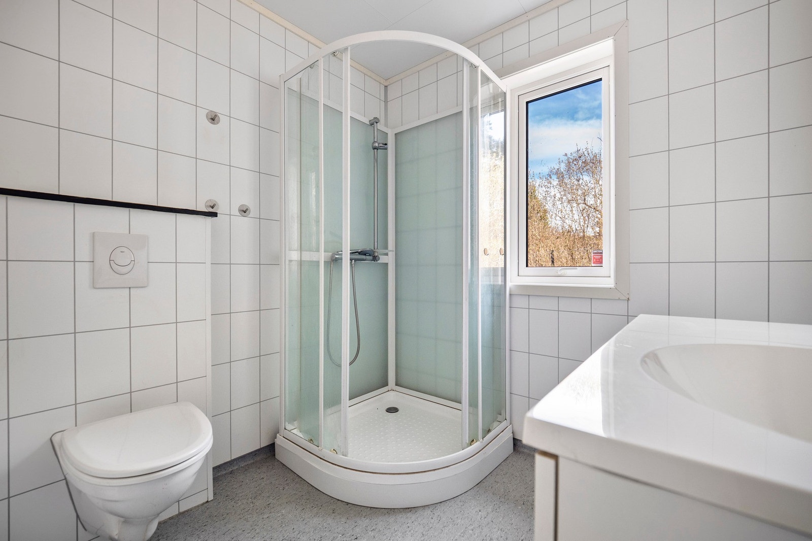 På badet er det dusjkabinett, vegghengt toalett og opplegg for vaskemaskin. Galleribilde