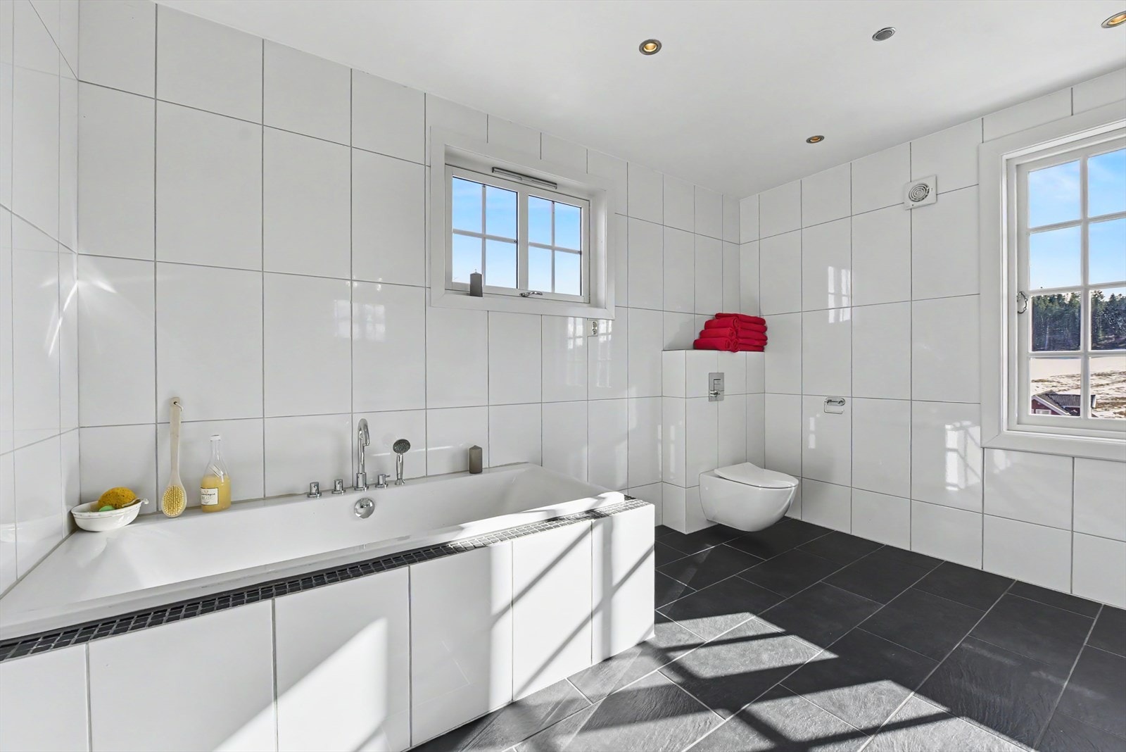 Badet har veggmontert toalett og avtrekksvifte på veggen. Galleribilde