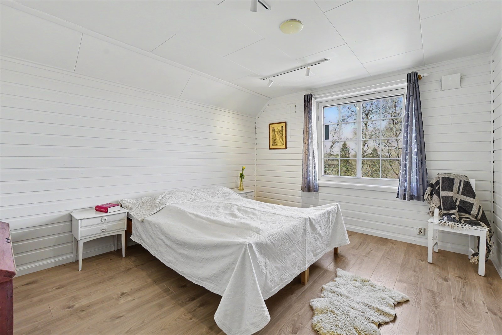 På loftet finnes også et romslig soverom med laminatgulv og panel på veggene. Galleribilde