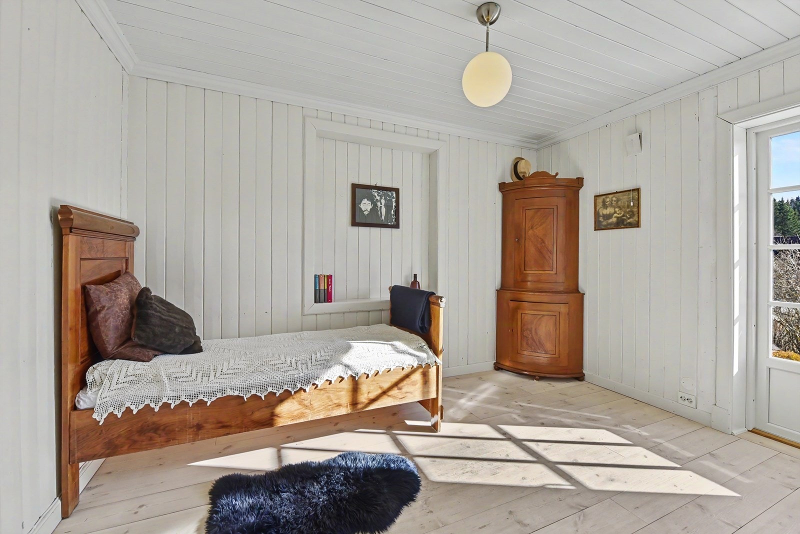 Rommet har panel på veggene og et lyst tregulv. Galleribilde