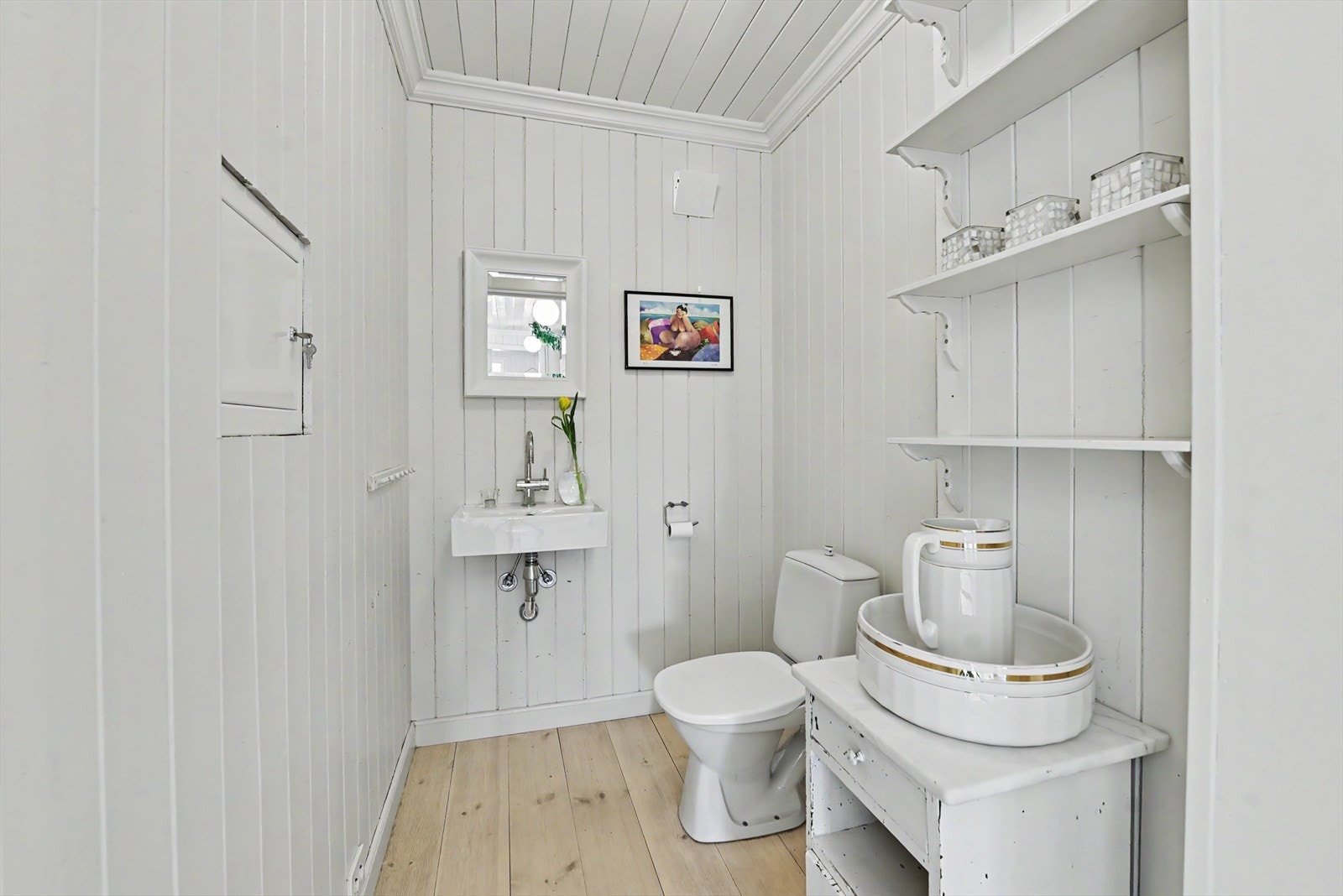 Toalettrom i første etasje med heltre på gulv, panel på veggene og gulvvarme. Galleribilde