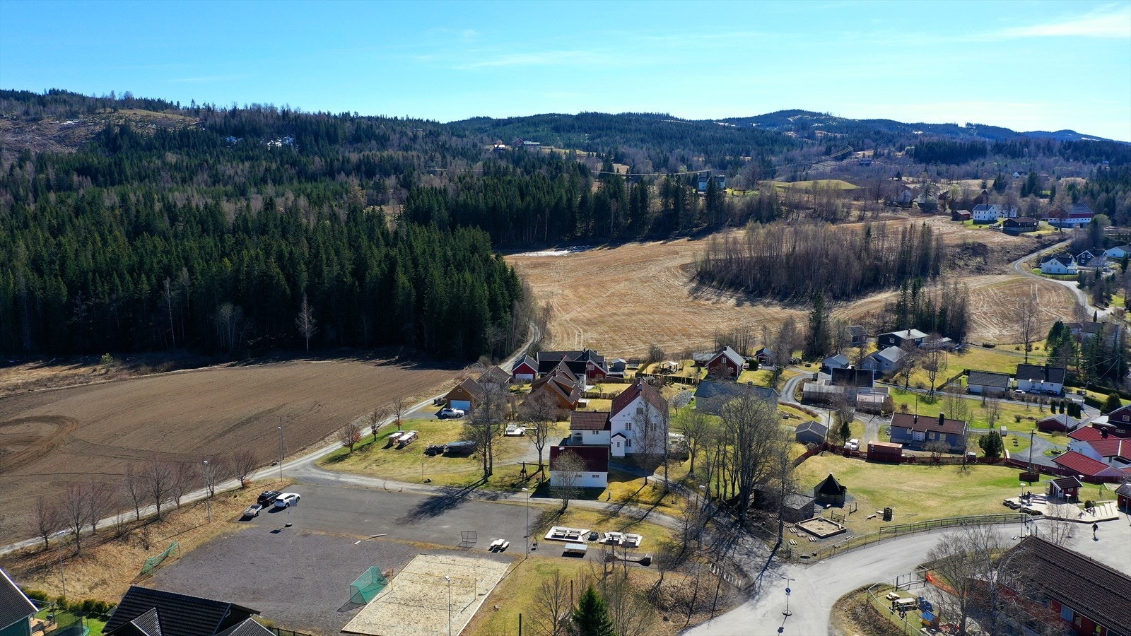 Eiendommen sett fra luften, med nærhet til både vann og skog. Galleribilde