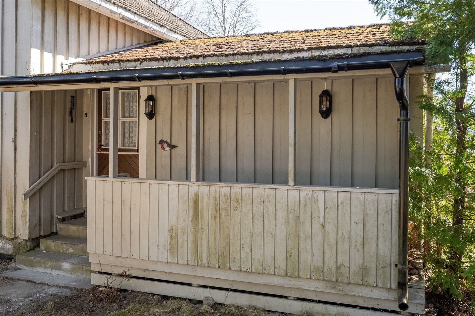 Det ene inngangspartiet har takoverbygg og murtrapp. Galleribilde