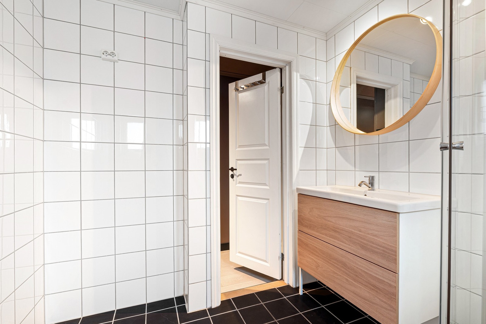 Badet er innredet med dusjkabinett, gulvmontert toalett, servant på underskap, og speil. Galleribilde