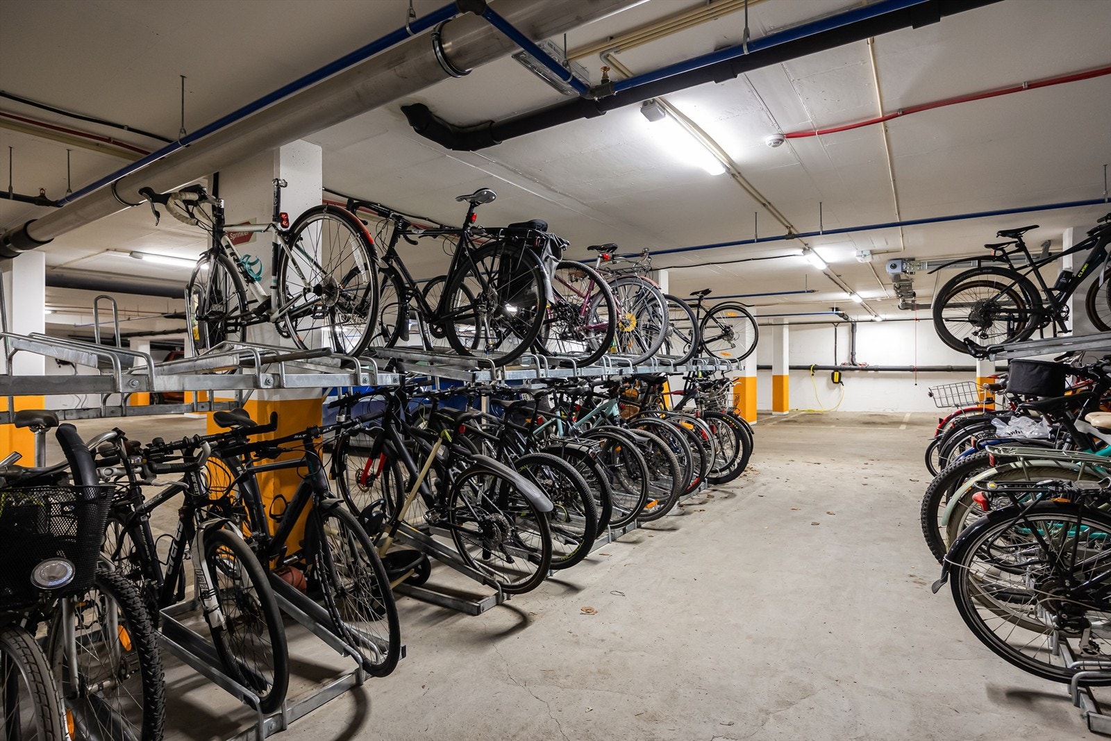 Stor felles sykkelparkering i tilknytning til garasjeanlegg i nabobygg. Tre andre felles sykkelparkeringer i fellesboder med god plass. Galleribilde
