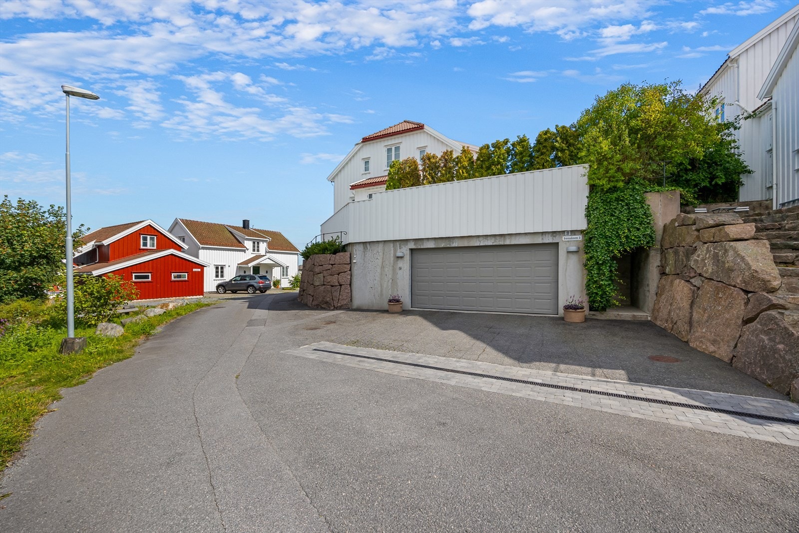 Bred garasjeport med biloppstillingsplasser foran. Galleribilde