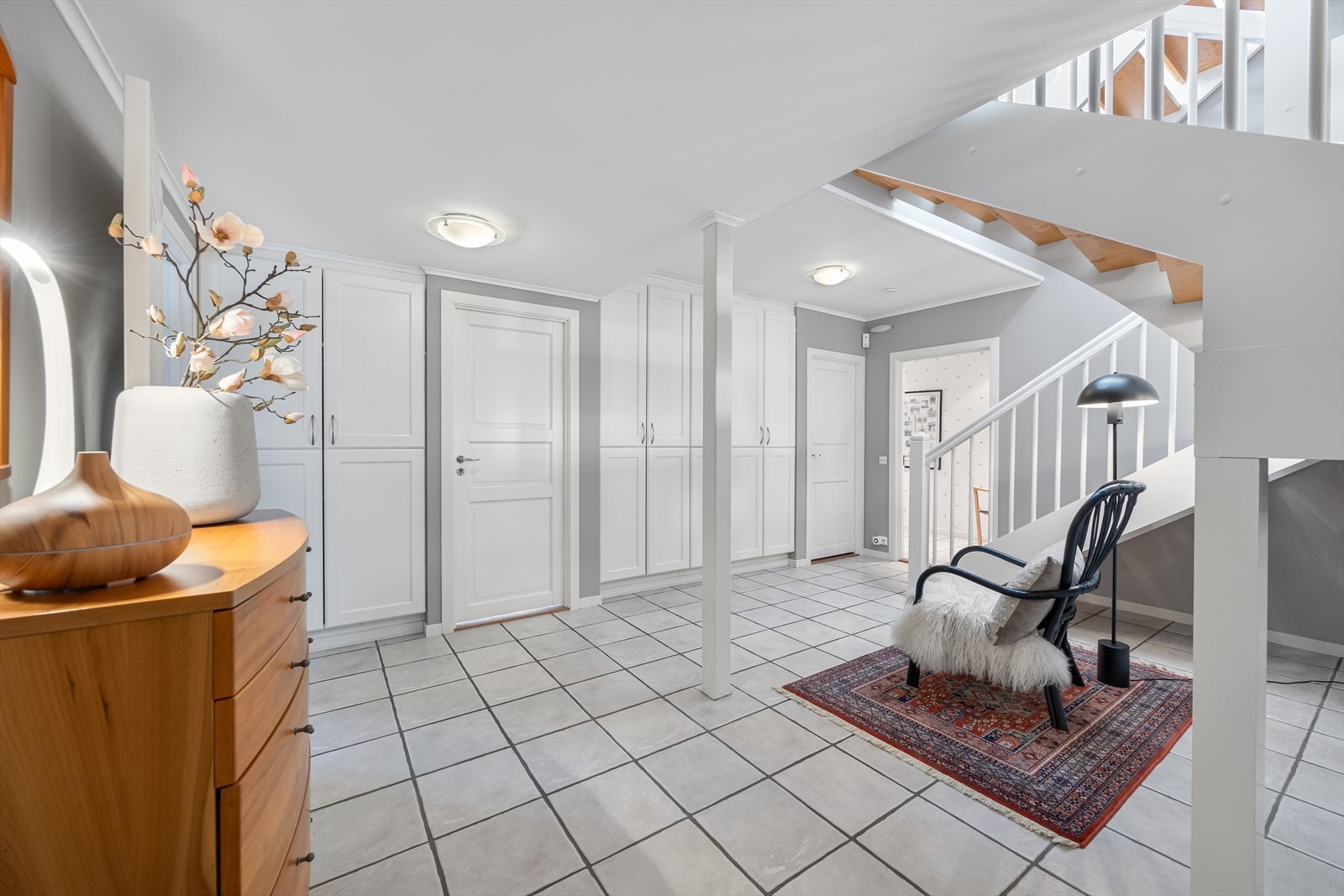 Romslig hall med fliser og bla. integrerte garderobeskap. Rommet gir adkomst til bad, vaskerom, stue, 2 boder, walk-in garderobe og garasje. Galleribilde