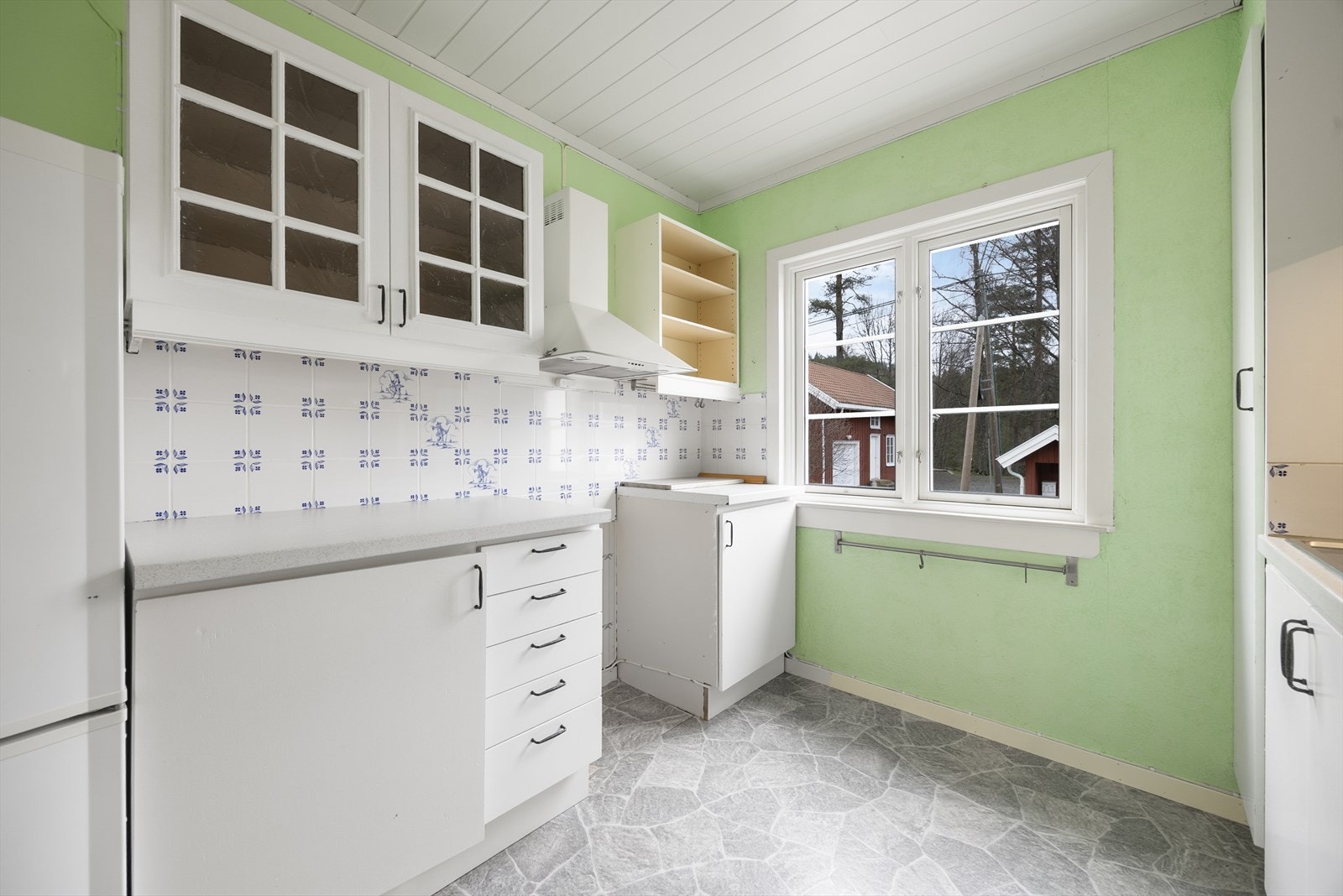 Kjøkkenet har innredning med glatte fronter, samt fronter med glass og laminert benkeplate med flis over. Over stekesone er det ventilator med avtrekk ut. Galleribilde