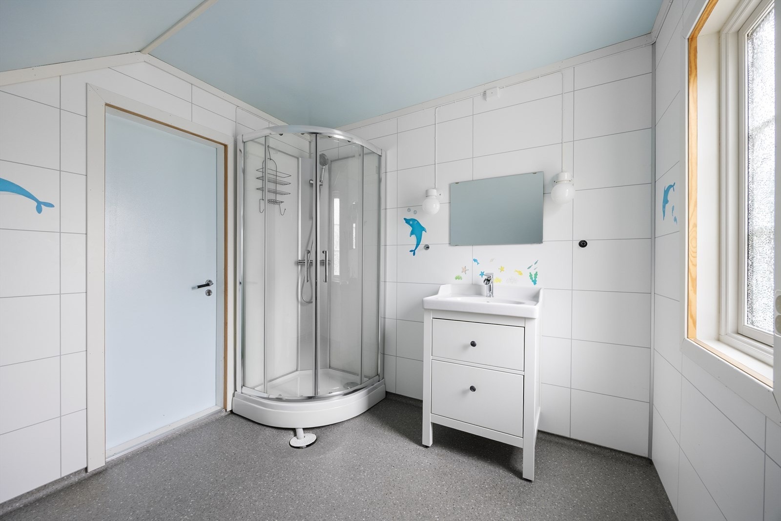Badet har flislagt gulv med varmekabler, våtromsplater på vegger og malte plater i tak. Galleribilde