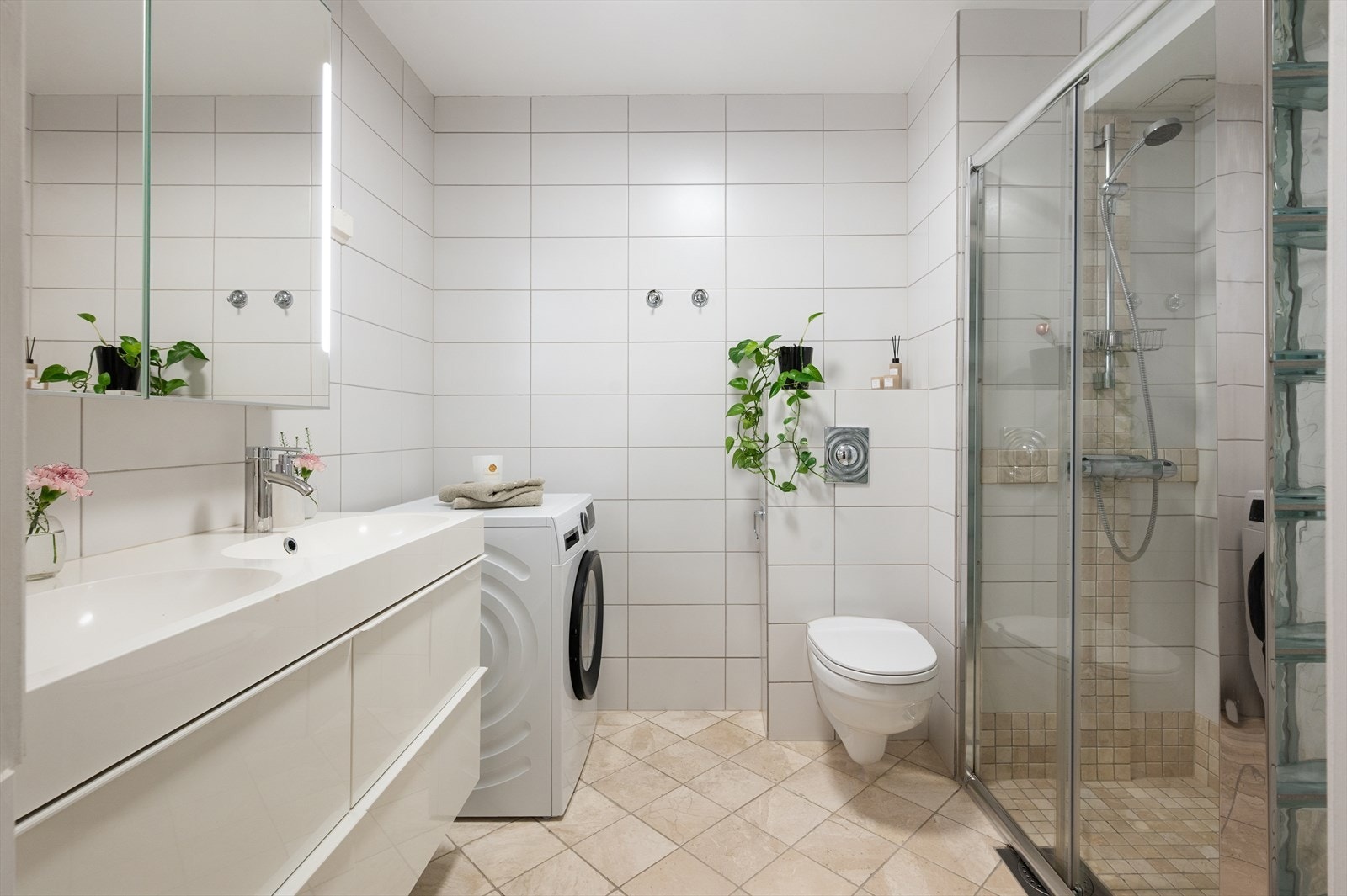 Romslig og pent bad med vegghengt toalett og dobbel servant nedfelt i innredning. Galleribilde